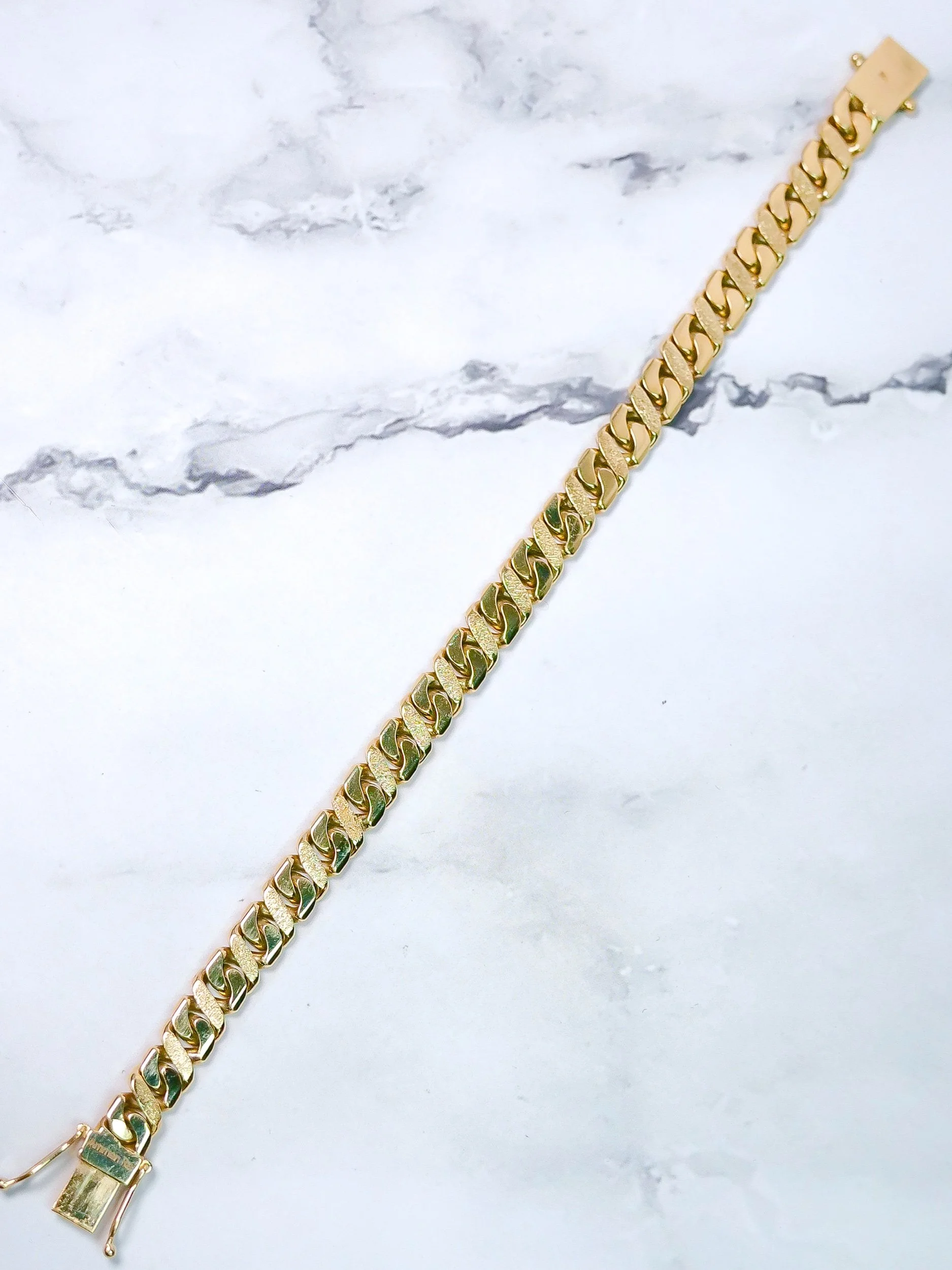 Close-up of diamond-cut and sandblasted figure 8 links, 9k gold bracelet