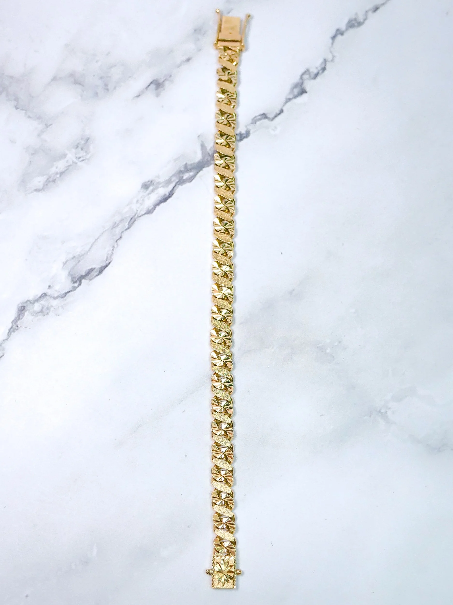 8mm figure 8 link bracelet in 9k gold, side view on marble