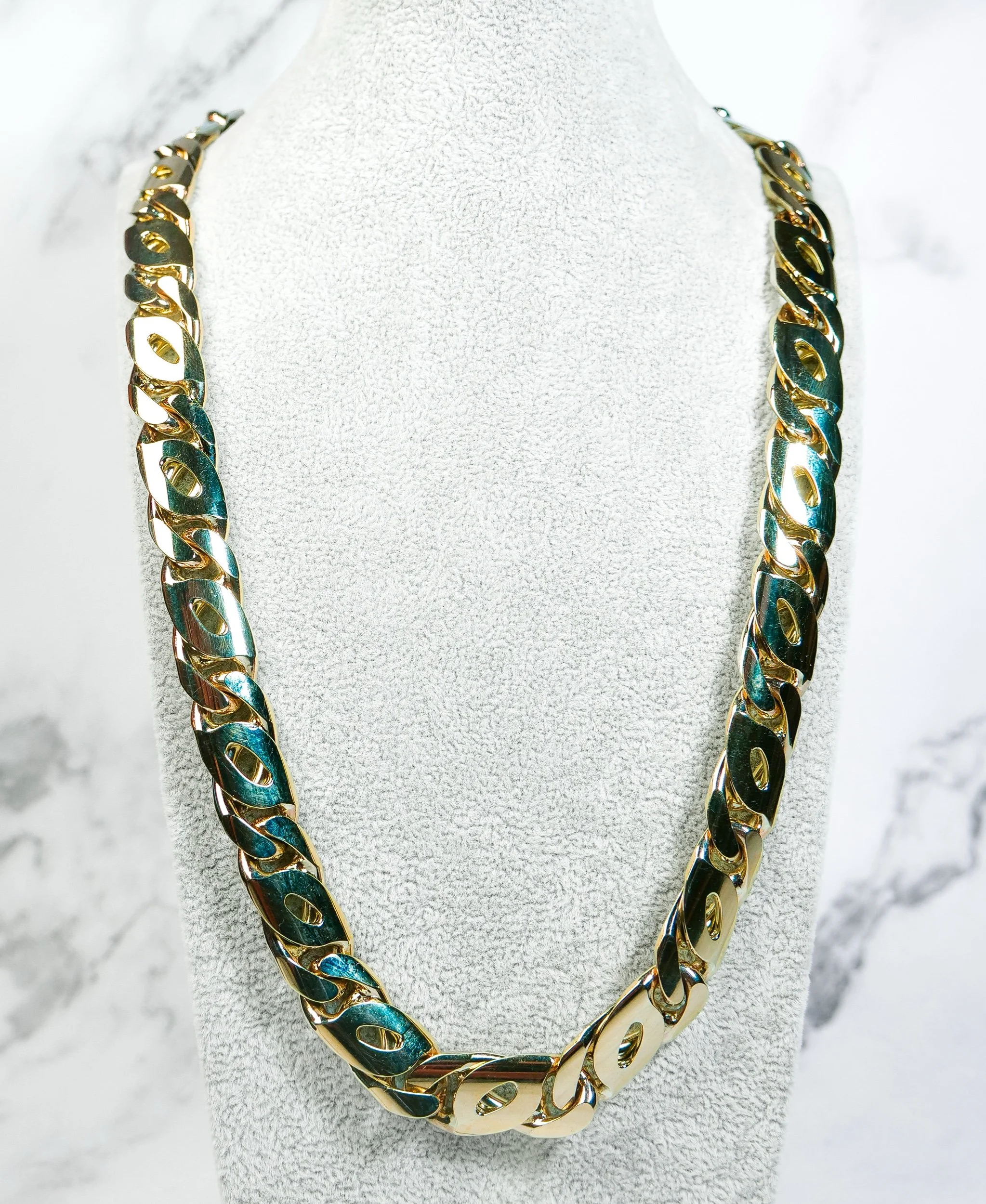 Heavy birdseye link chain in 9k gold displayed on a white neck bust