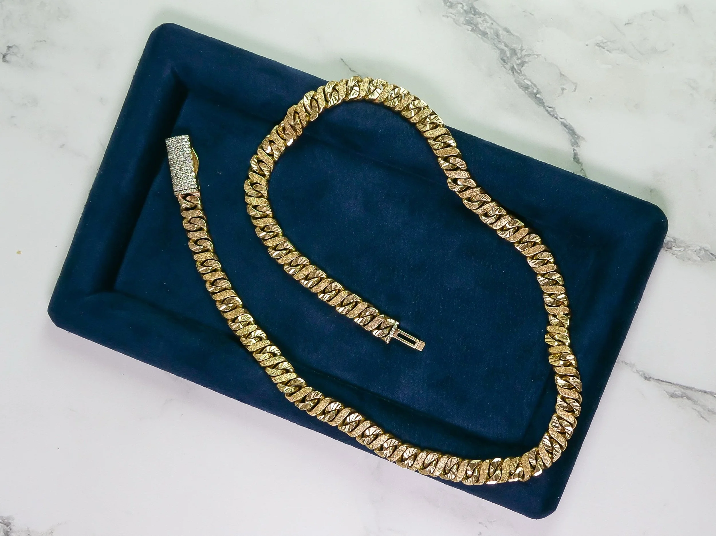 10mm diamond-cut figure 8 link chain in solid 9k yellow gold on a navy display