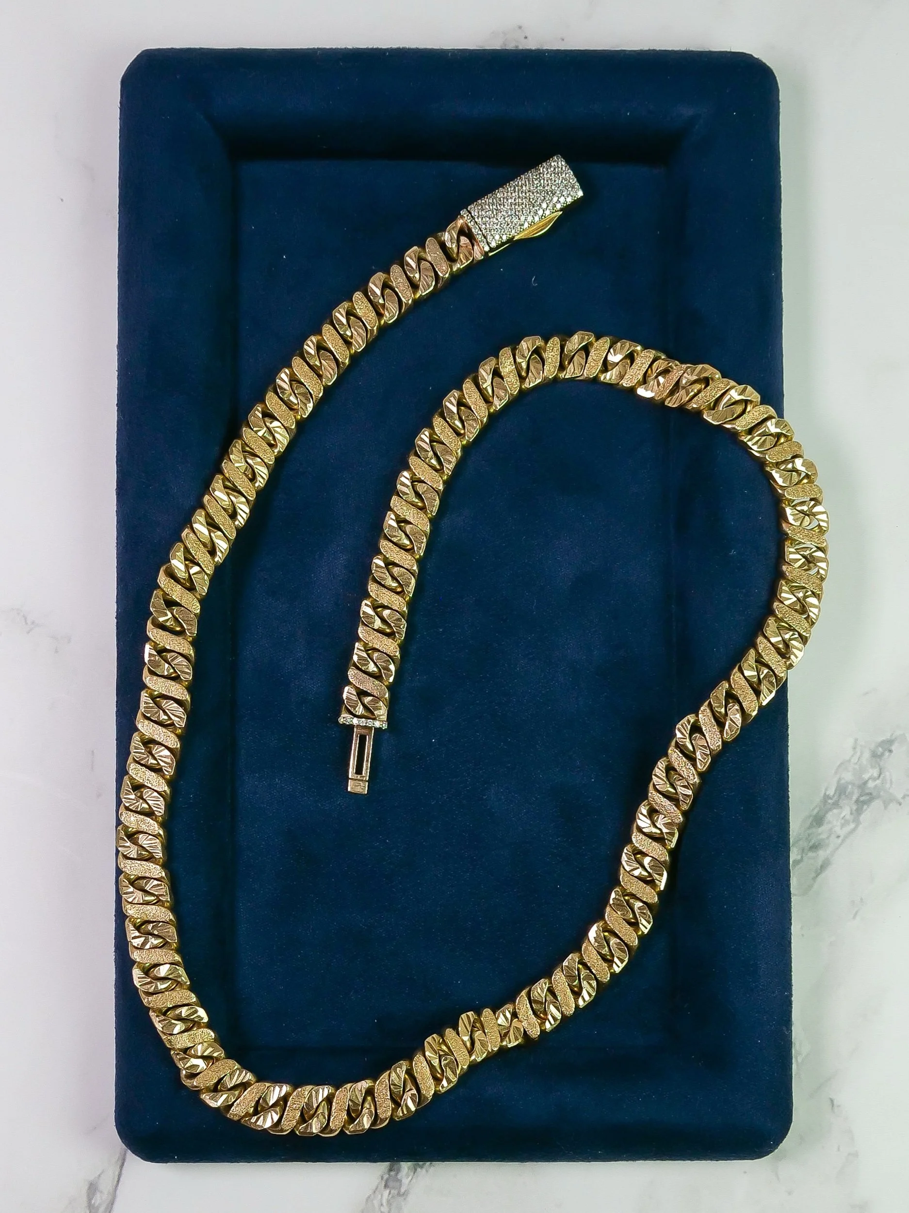 Close-up of diamond-cut and sandblasted figure 8 links in 9k gold
