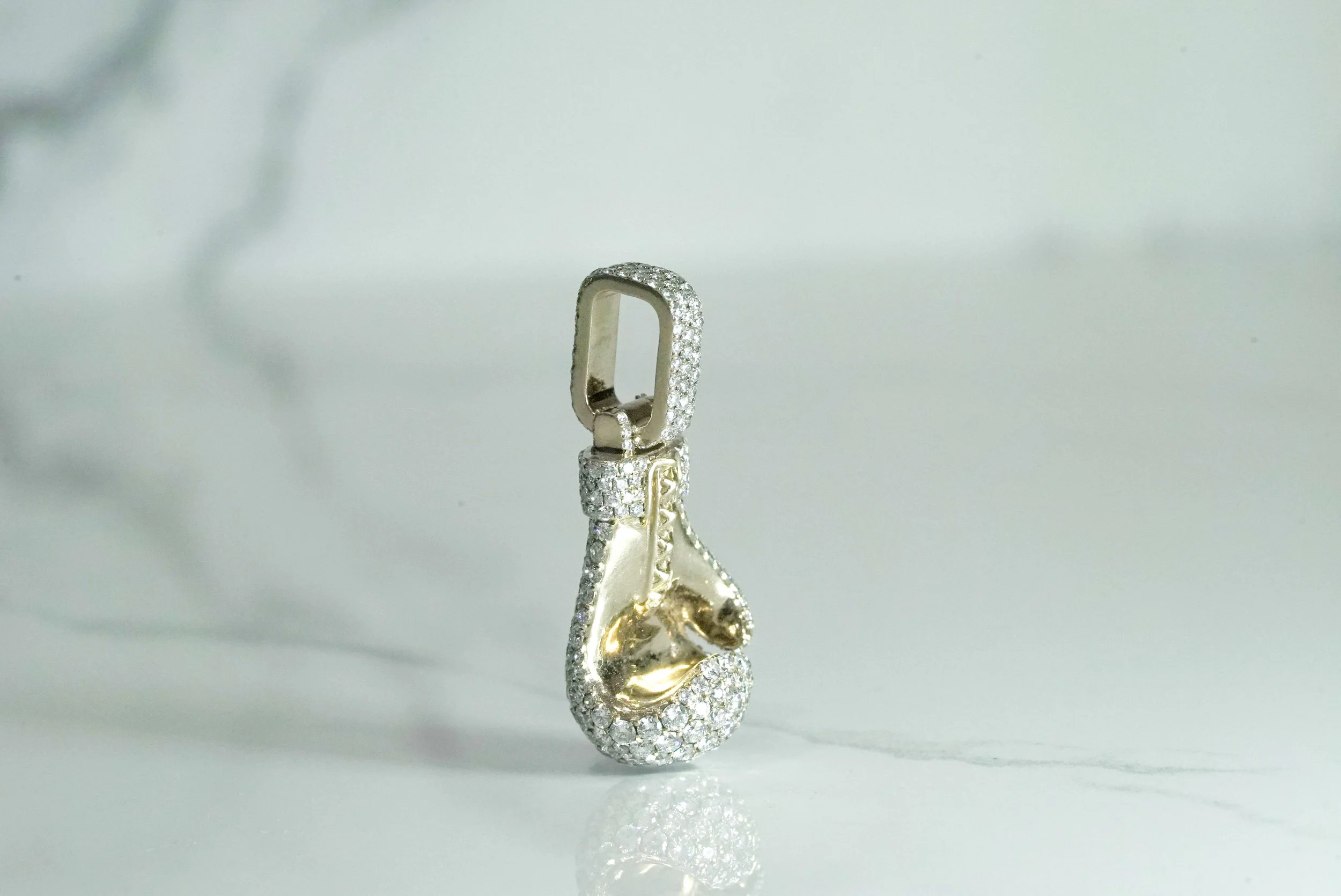 The Champion diamond boxing glove pendant in 9k gold, angled view