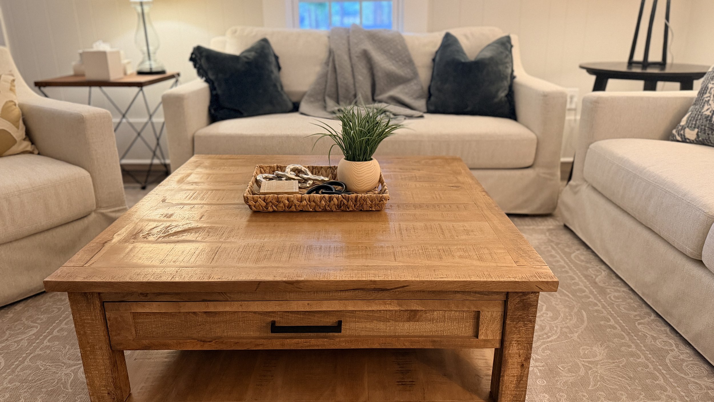 Close-up of an immaculate rustic wooden coffee table with a decorative tray, styled as part of a vacation rental cleaning service by TerraPro.⁠