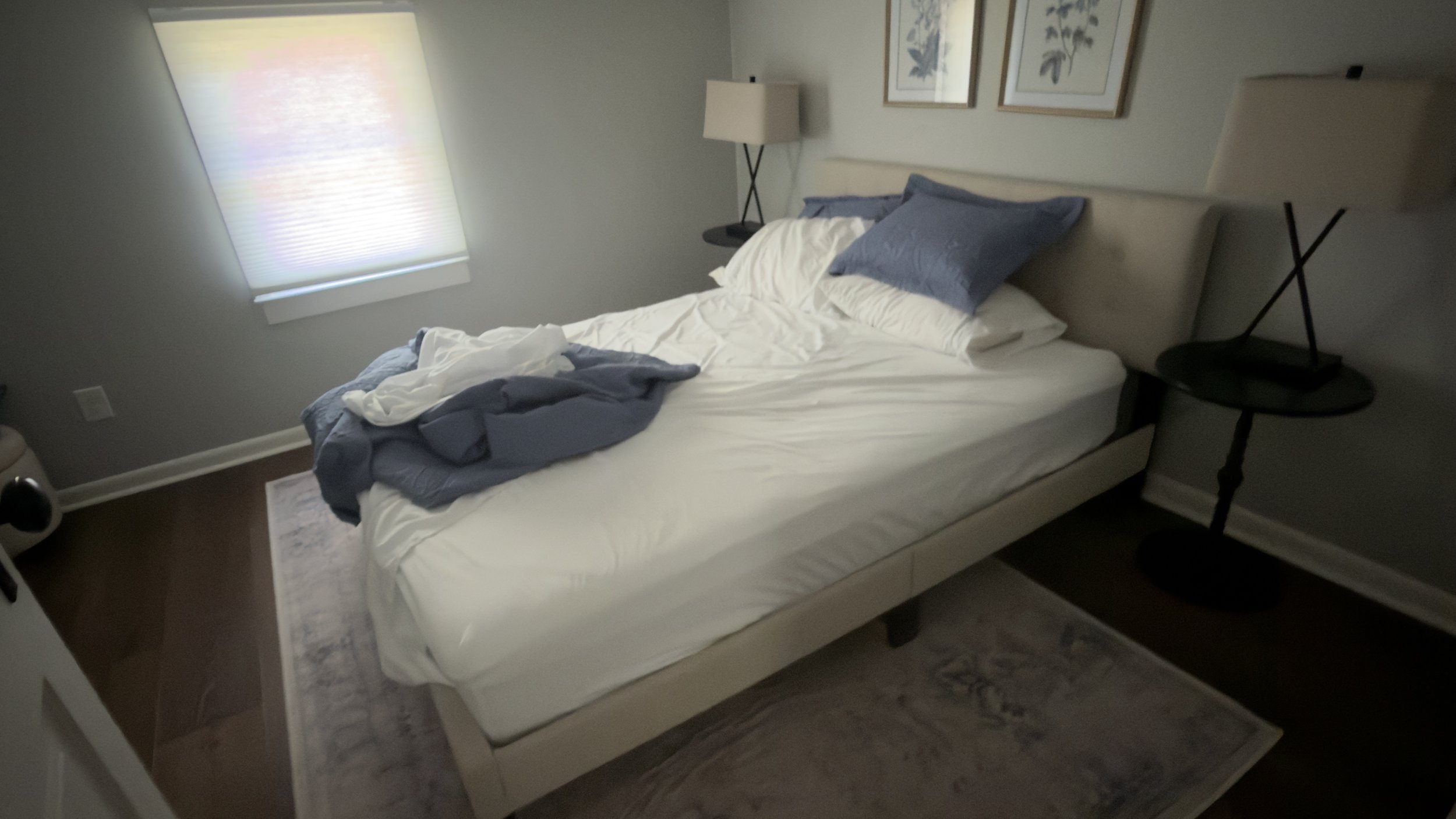 A messy, slept-in guest bed with rumpled white sheets and unmade blankets inside a vacation rental bedroom prior to turnover cleaning.⁠