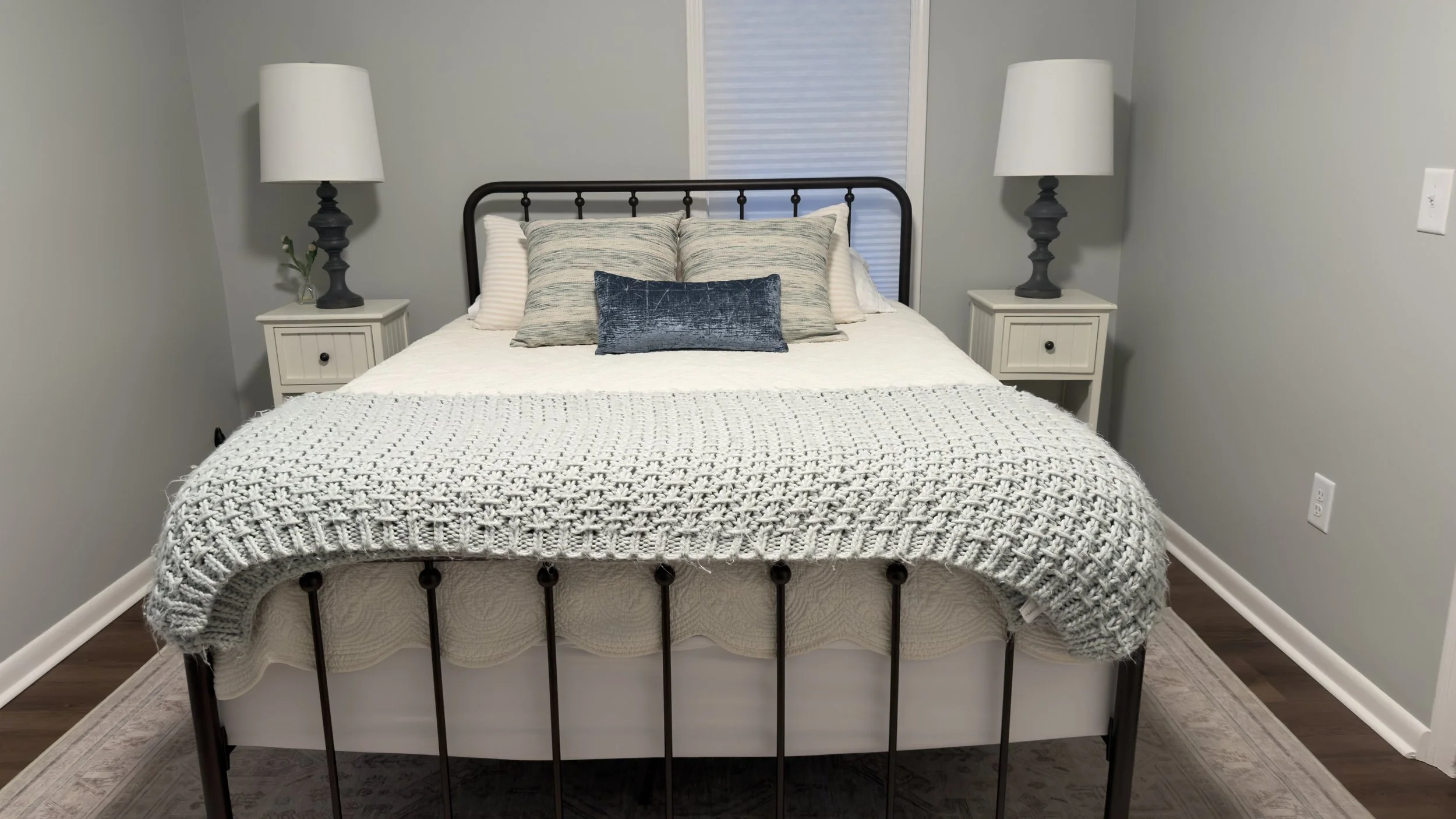 A perfectly made queen bed framed by matching white nightstands and black lamps, showcase of a luxury residential maid service by TerraPro.⁠