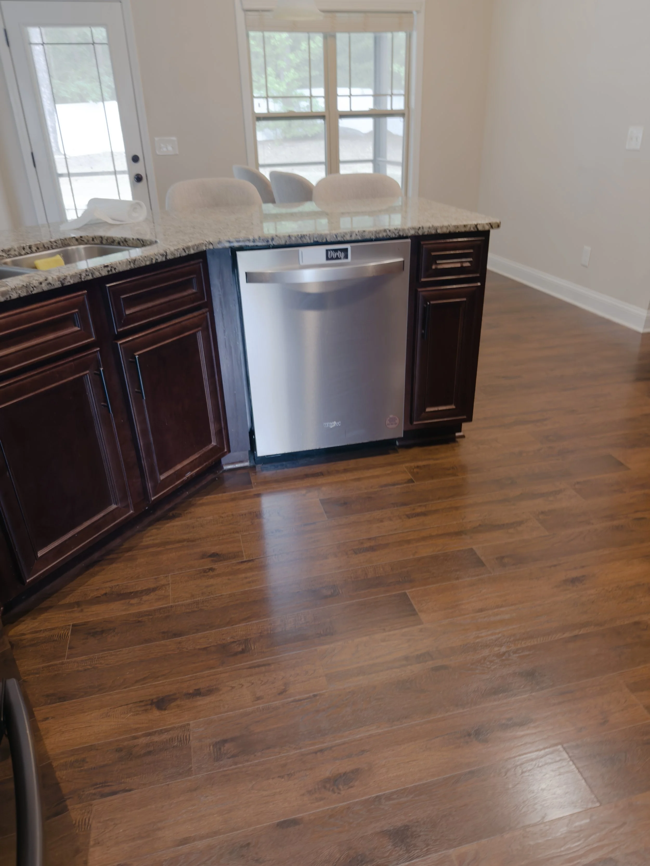 Gleaming, flawlessly polished specialty hardwood kitchen floors wrapping around a granite island after a professional move-out deep clean by TerraPro.⁠
