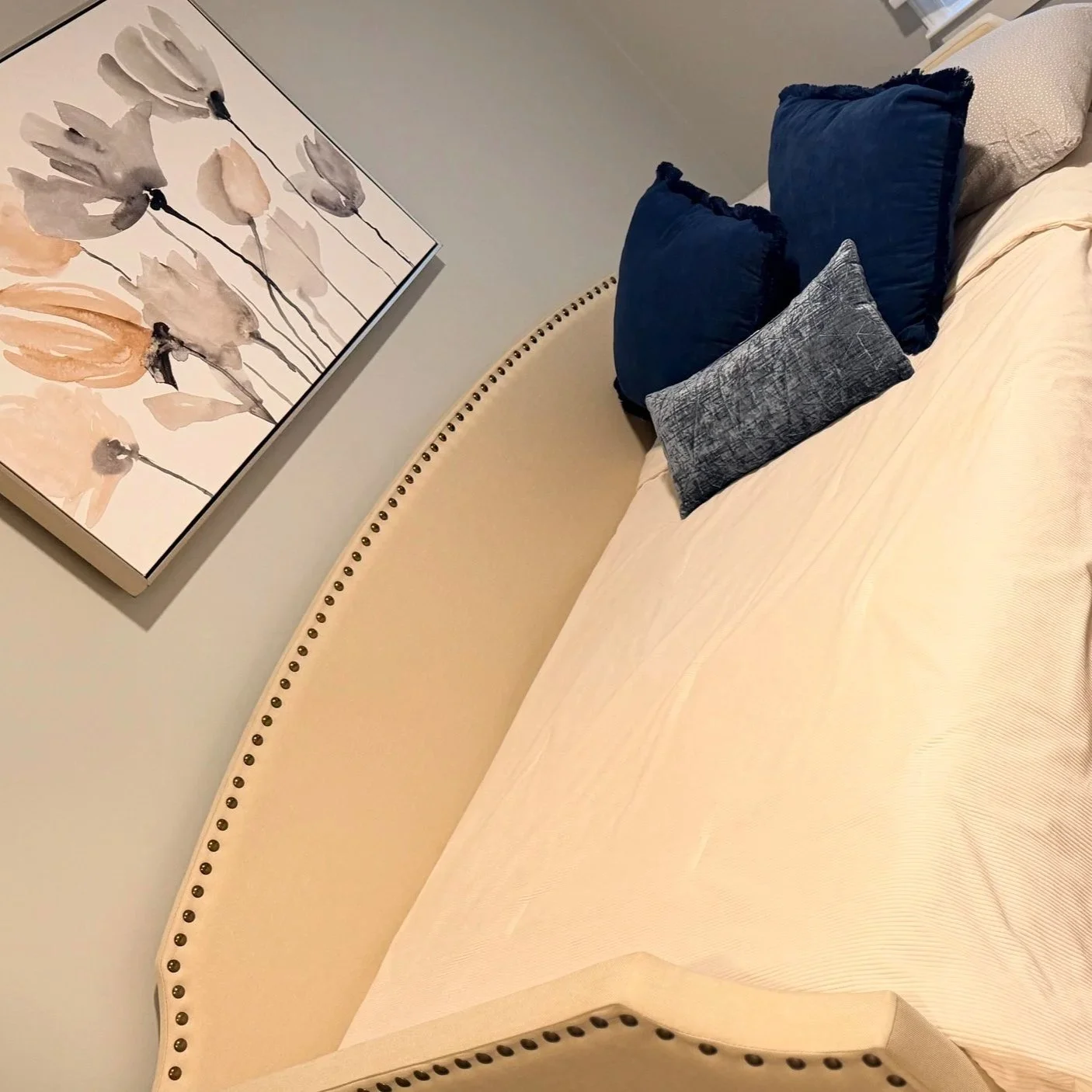 Angled view of an immaculately cleaned bedroom featuring a pristine cream daybed and floral wall art, managed by Kosmos Residential Suite.⁠
