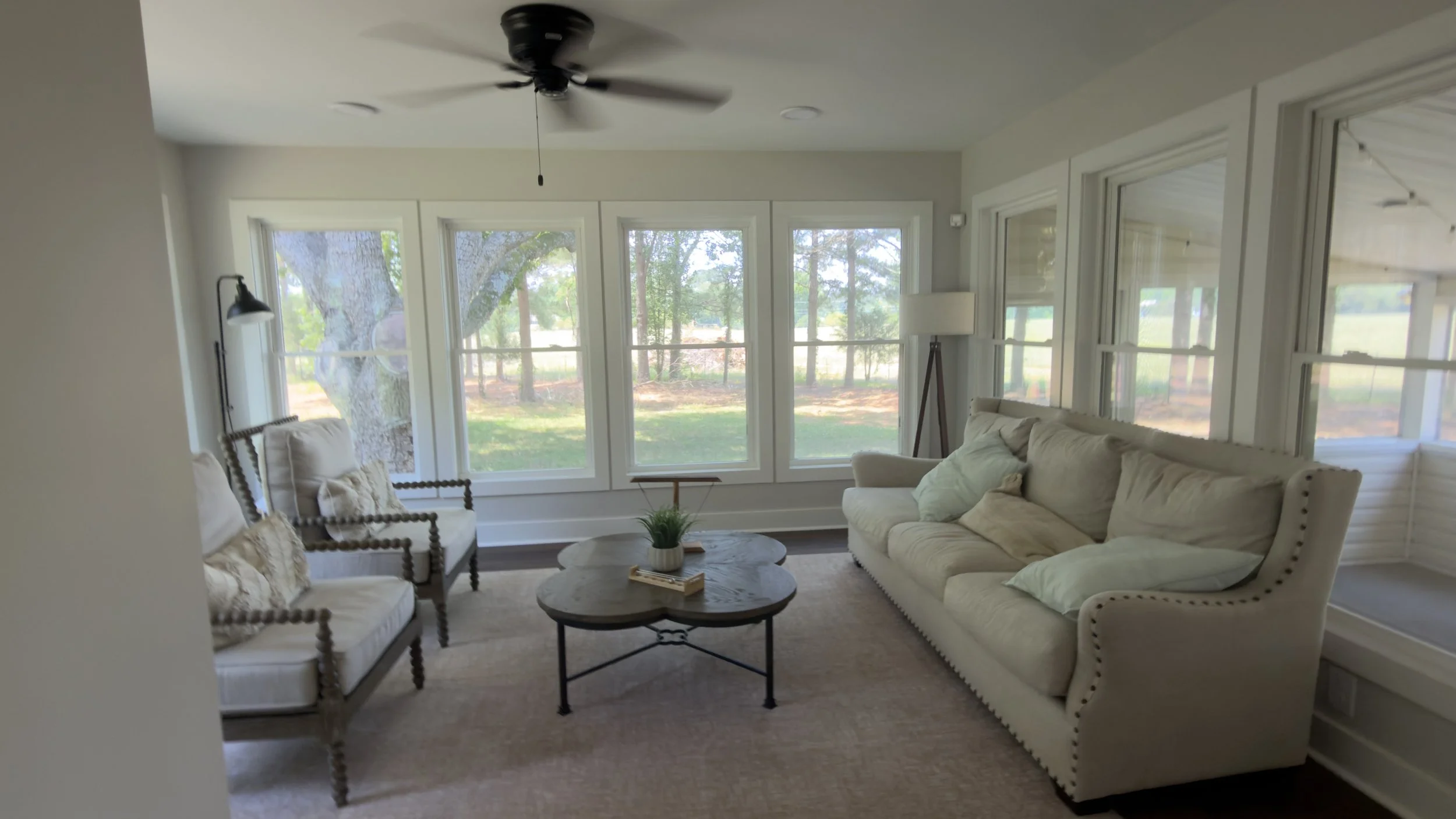 Disarranged furniture and unaligned armchairs in a vacation rental sunroom prior to a professional turnover cleaning service by TerraPro.⁠