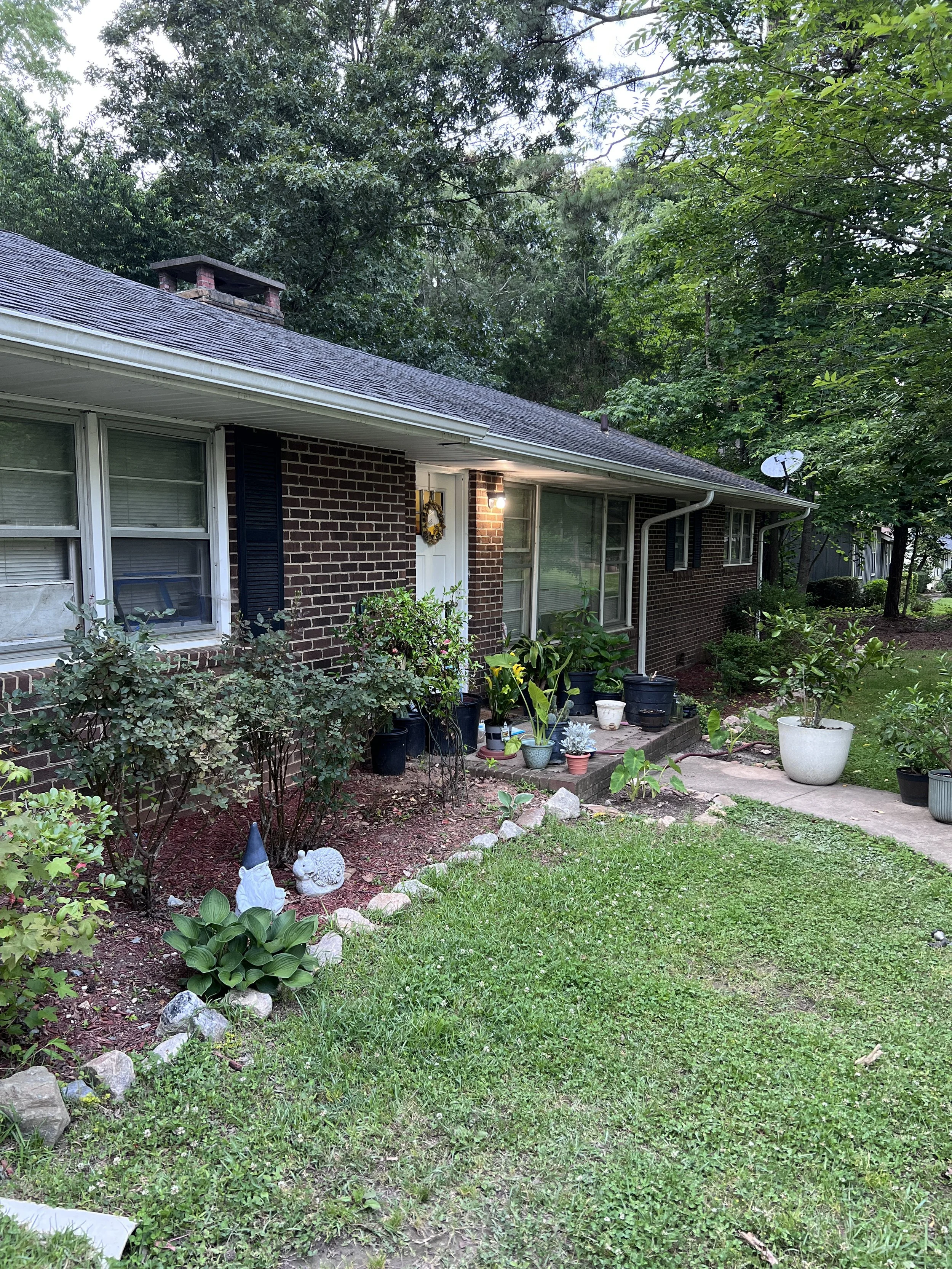 A beautifully landscaped brick ranch home on Creedmoor Road, showcasing pristine curb appeal after a recurring residential deep clean by TerraPro.