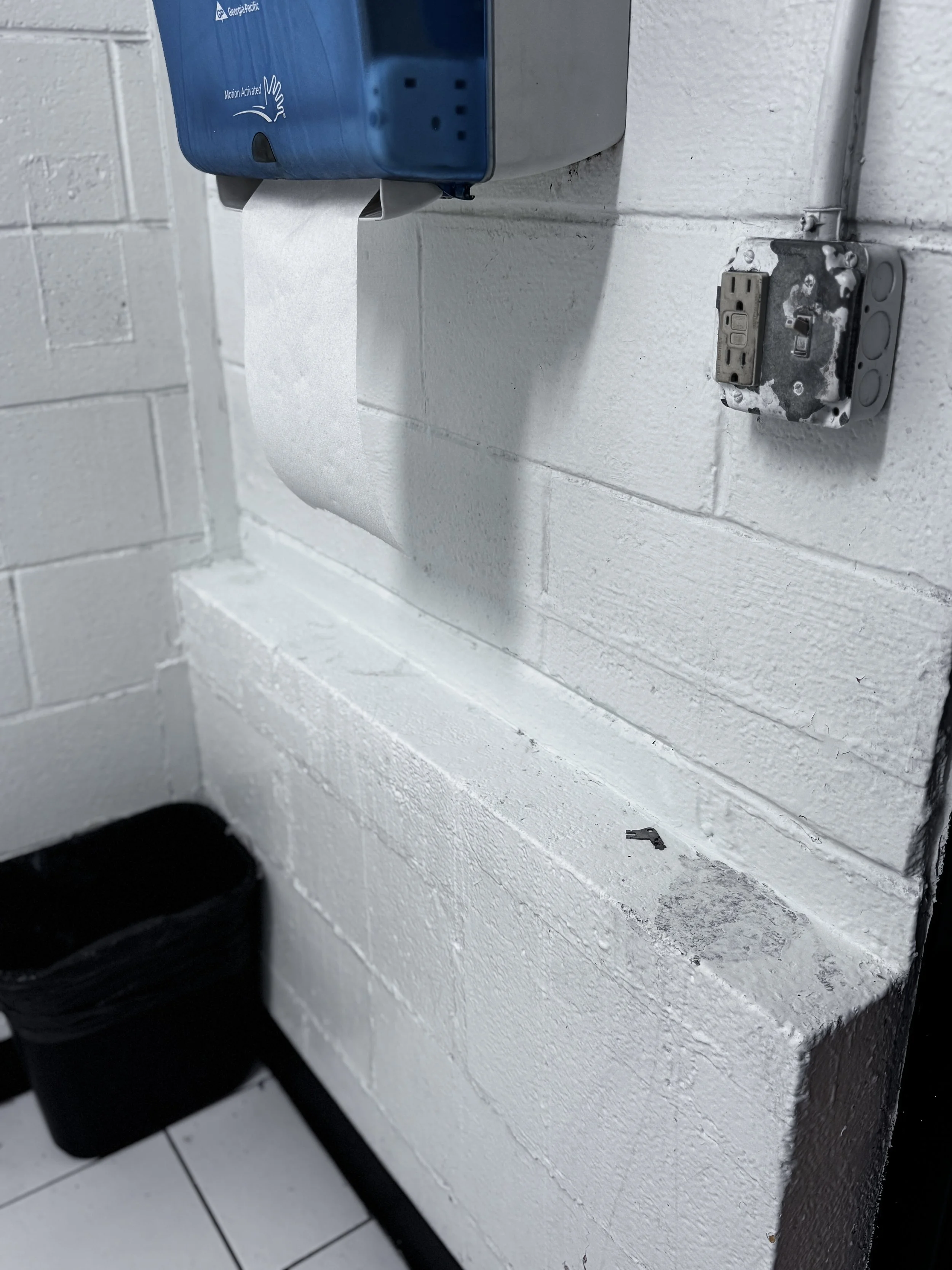 A completely white, sanitized, and deeply scrubbed concrete block wall ledge inside a commercial restroom at ULCS in Winston-Salem, NC.⁠