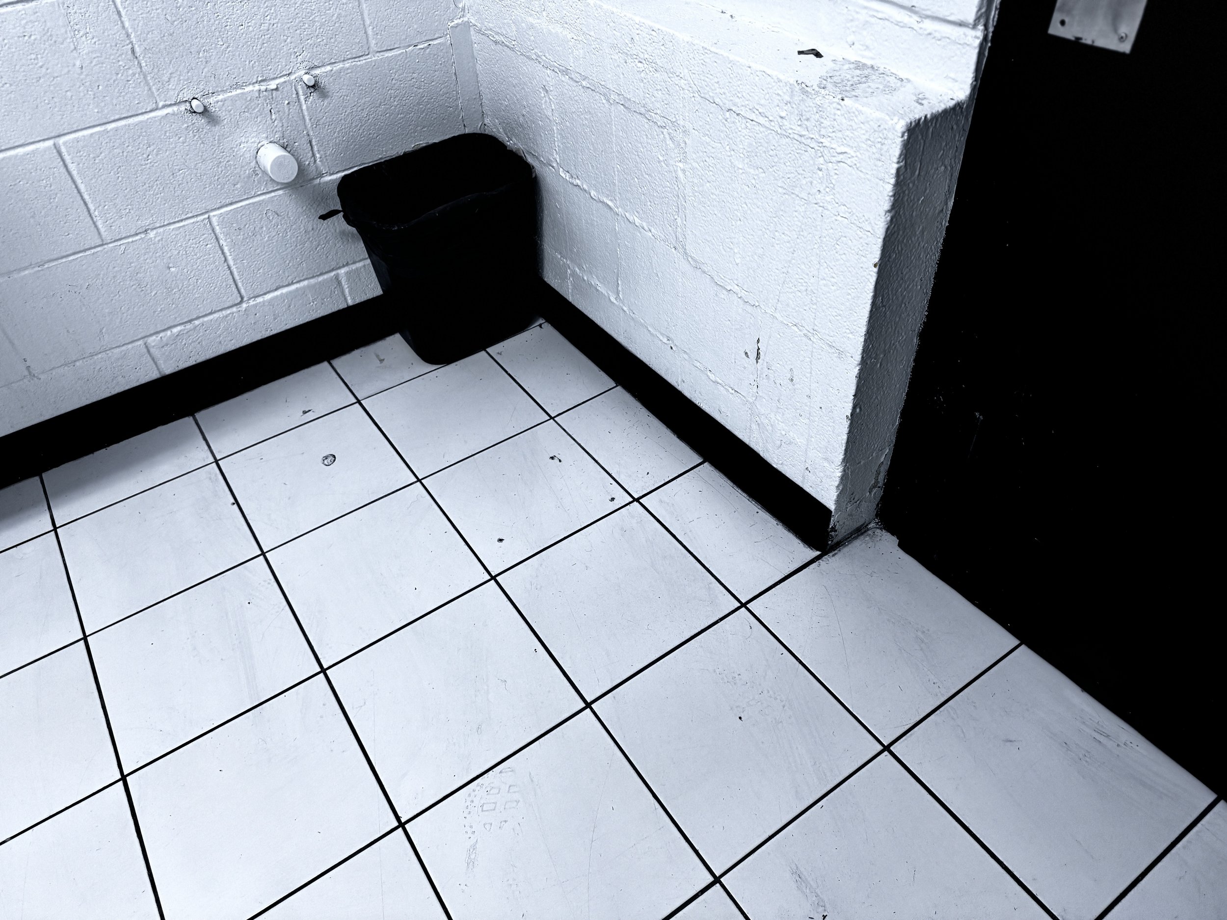 ⁠A sparkling clean and thoroughly disinfected commercial restroom tile floor with a clean black waste basket at the Winston-Salem ULCS facility.⁠