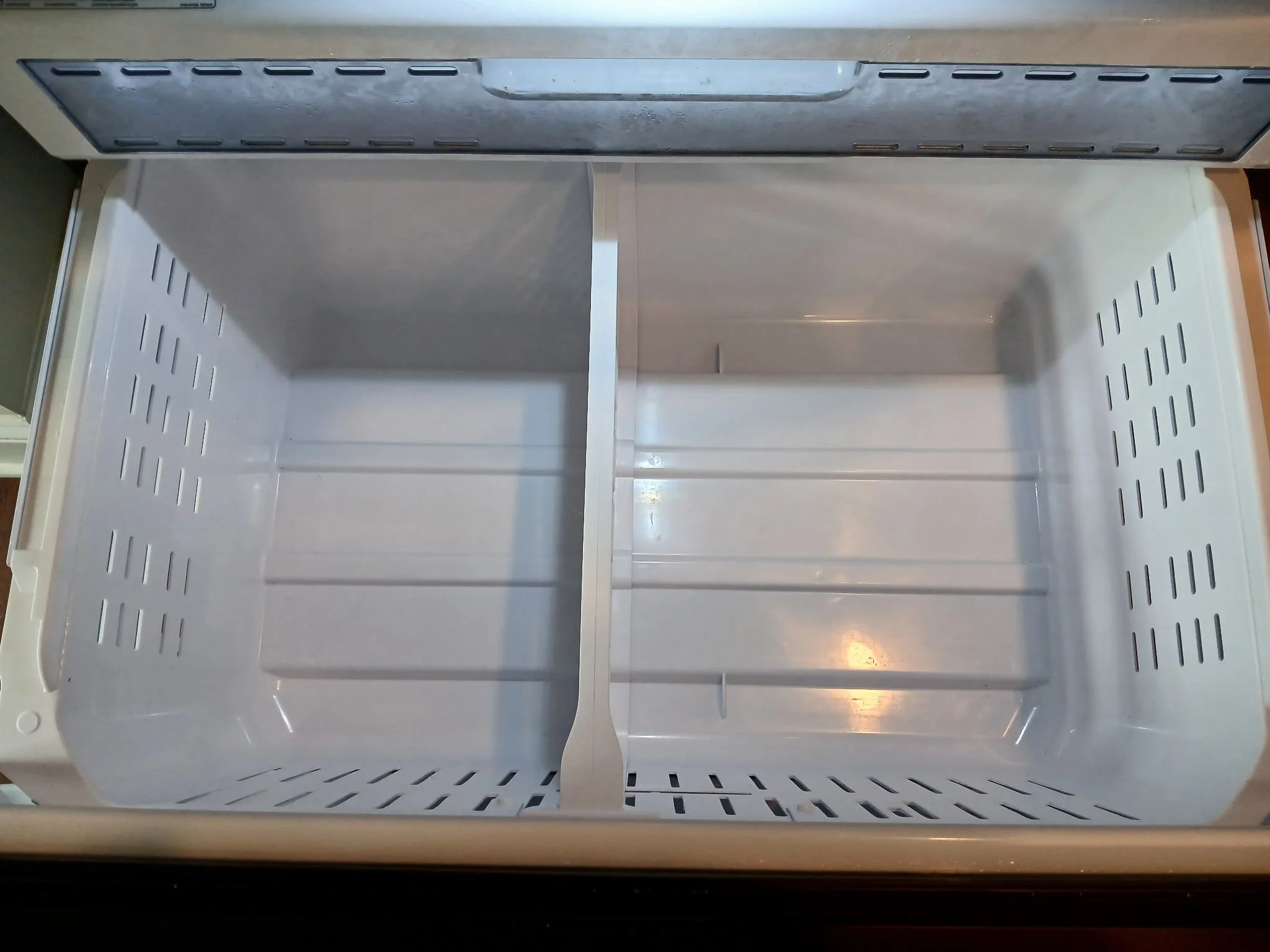 ⁠After view of a completely washed, sanitized, and spotless white freezer basket drawer, illustrating thorough move-out appliance restoration by TerraPro.⁠