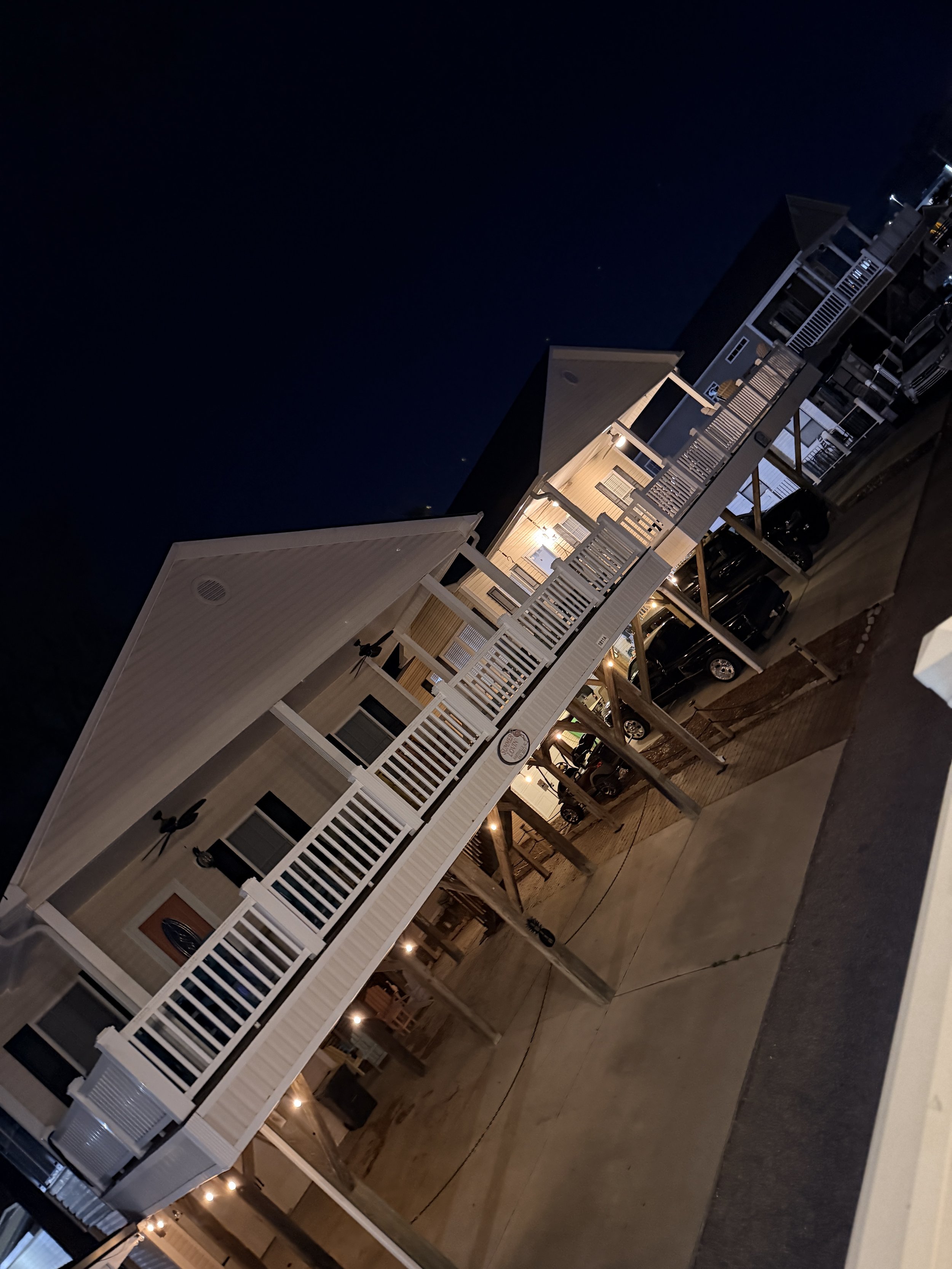 A stunning twilight view of a coastal beach house vacation rental in Topsail Beach, NC, immaculate and ready for guests following a premium turnover service.