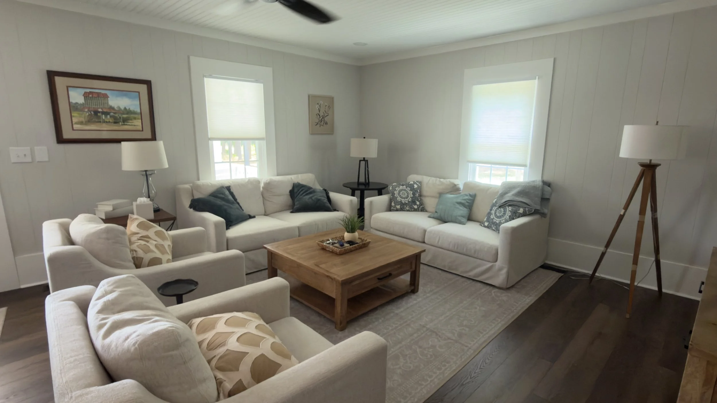 Professionally staged living room with clean white sofas, a large wooden coffee table, and an area rug during a premium Airbnb turnover service by TerraPro.