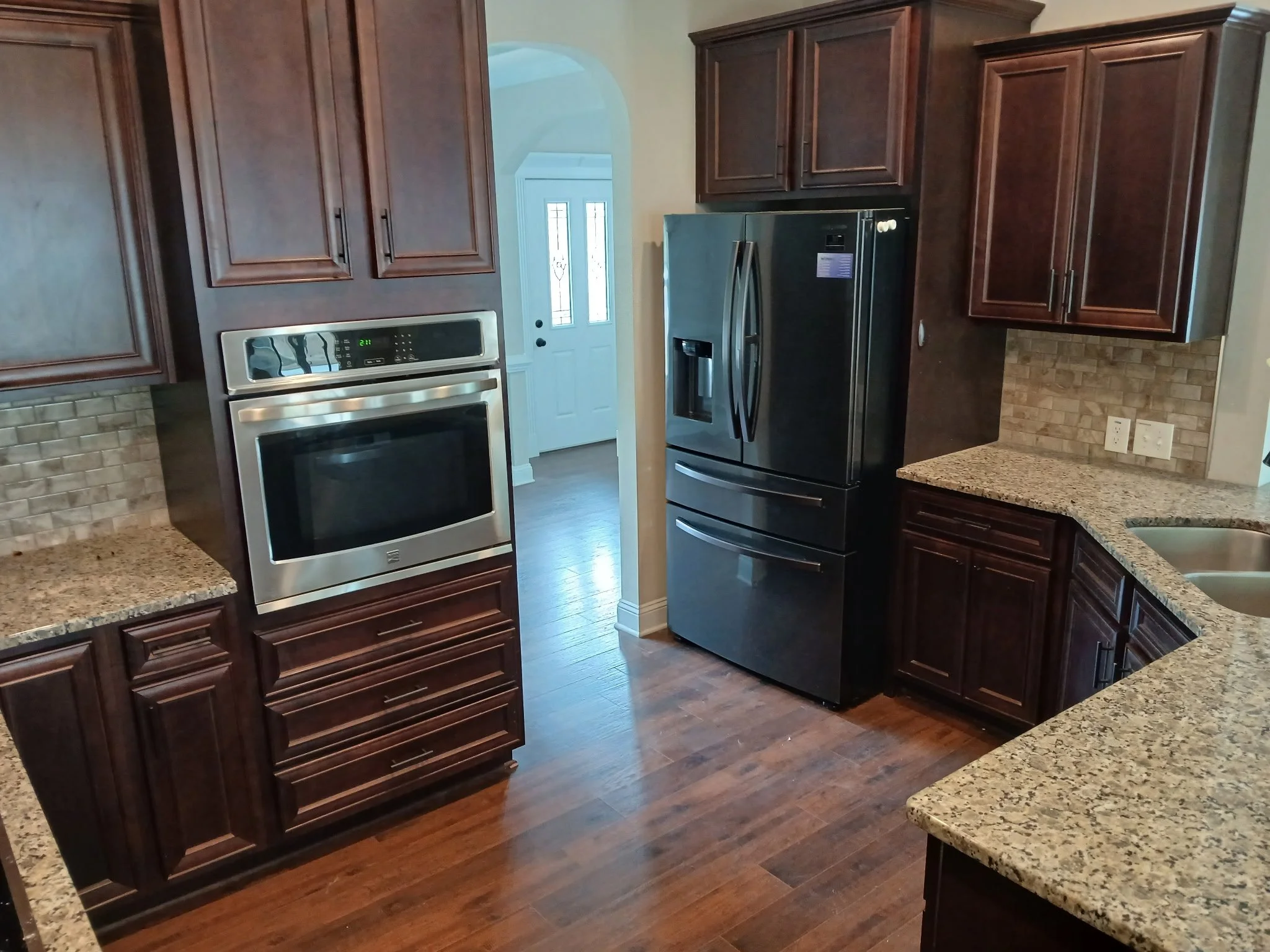 ⁠A dusty, hazy kitchen hardwood floor covered in post-move residue prior to a residential move-out deep clean for RW Realty NC.⁠