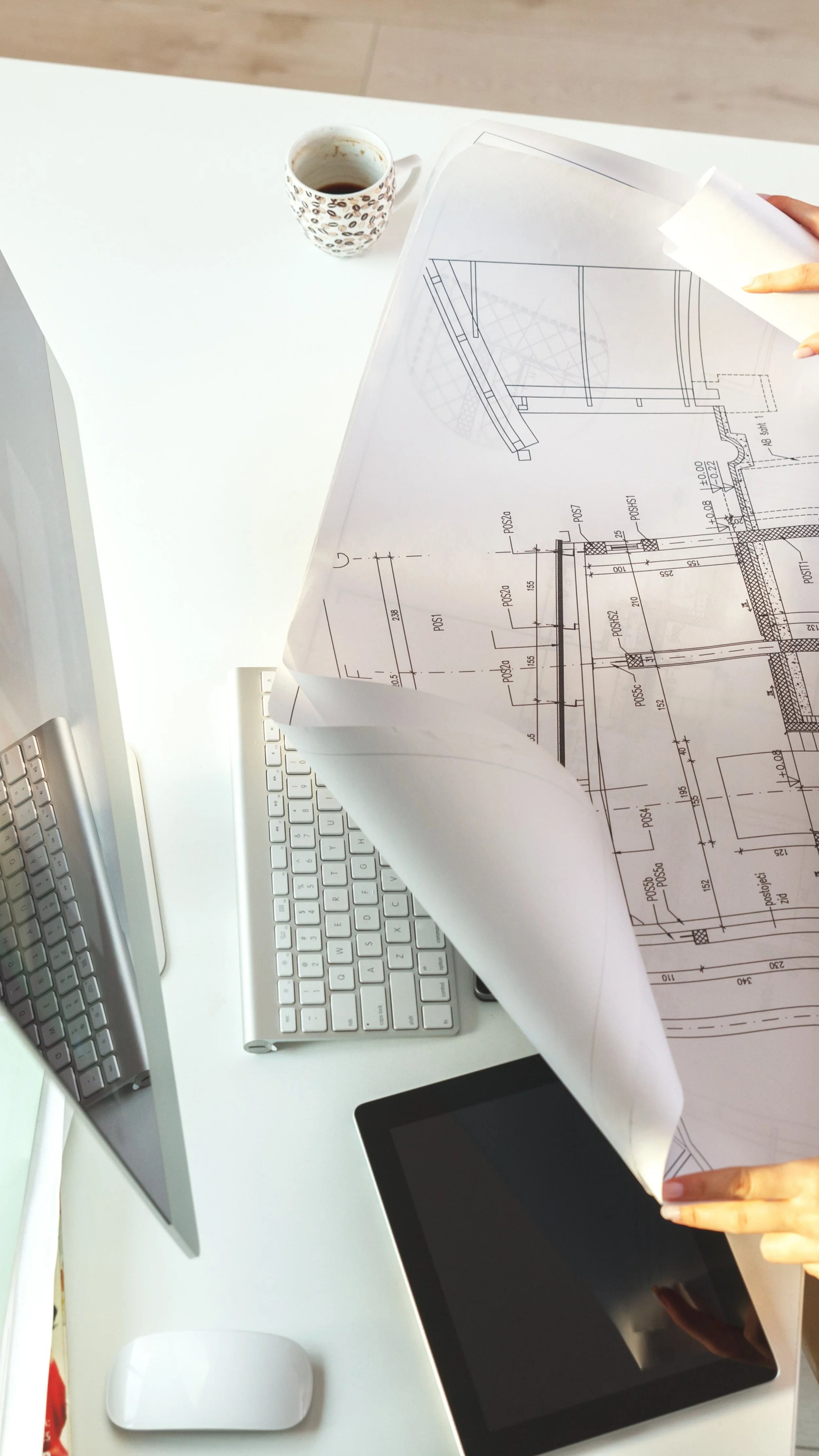 Arbeitsplatz mit Plänen auf welchen architektonischen Zeichnungen zu sehen sind