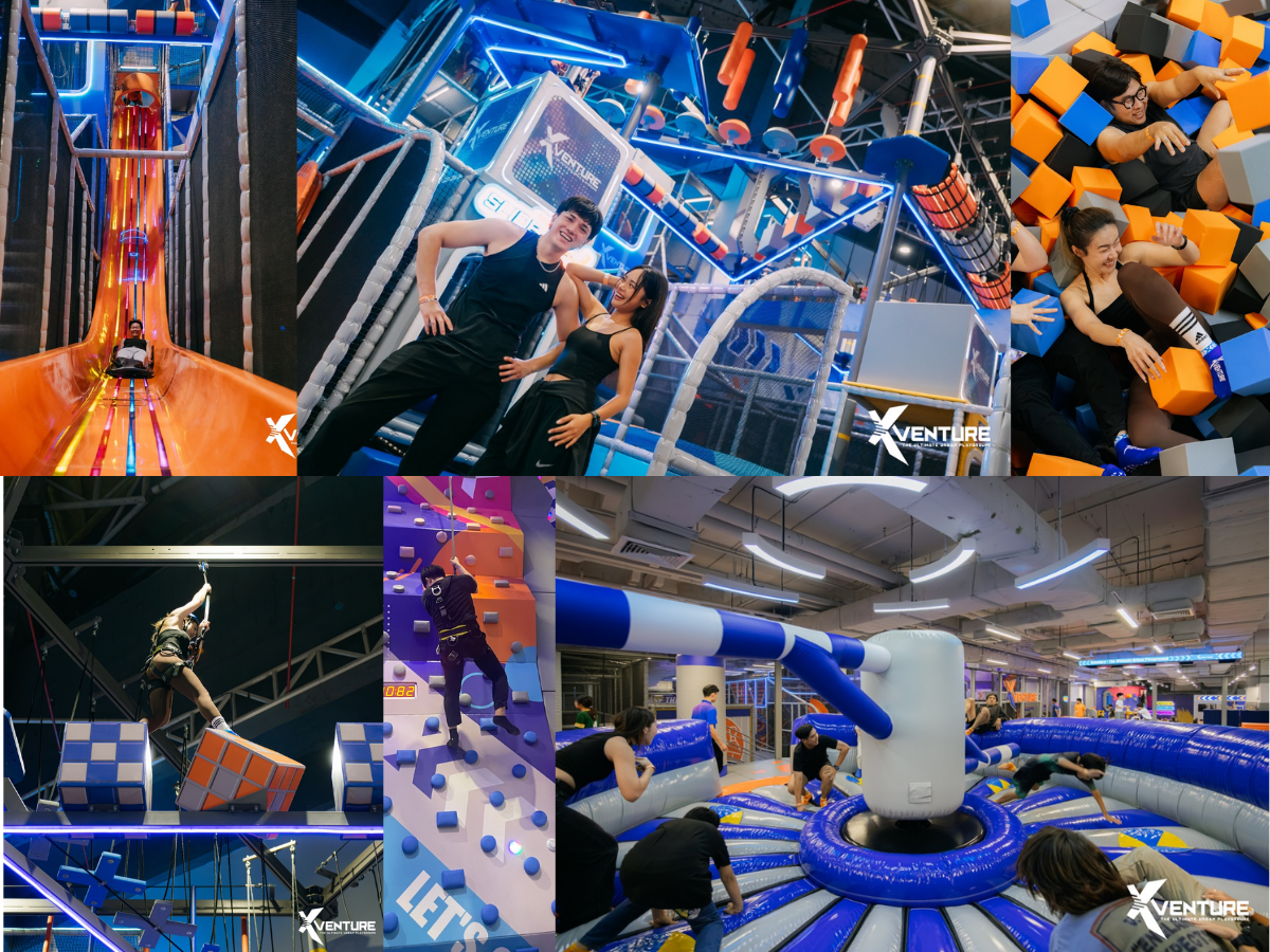 Group of people enjoying an indoor amusement park with various activities including a slide, climbing walls, foam pits, obstacle course, and trampoline area.