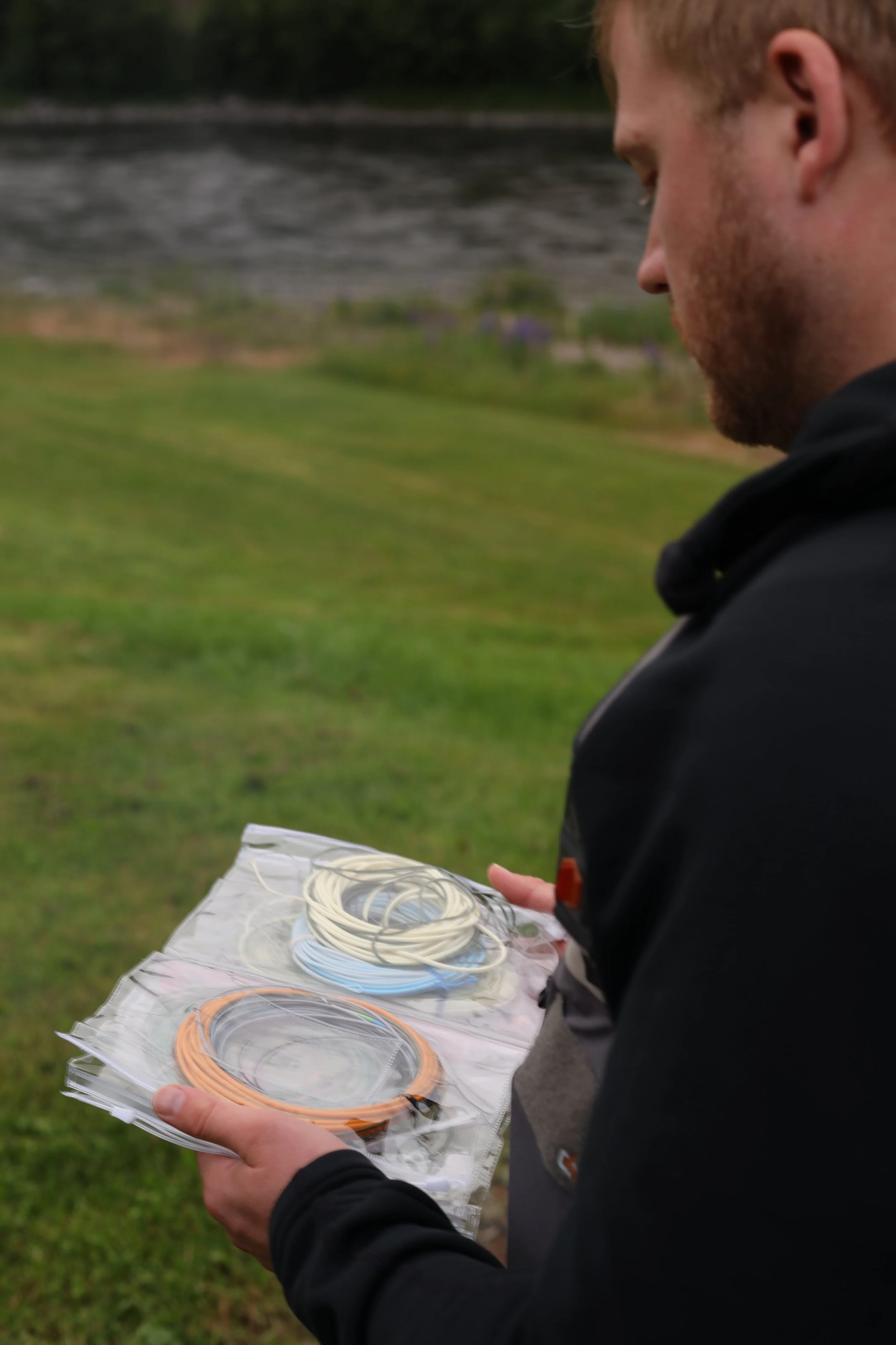 A person holding a plastic bag with neatly coiled colorful rubber bands.