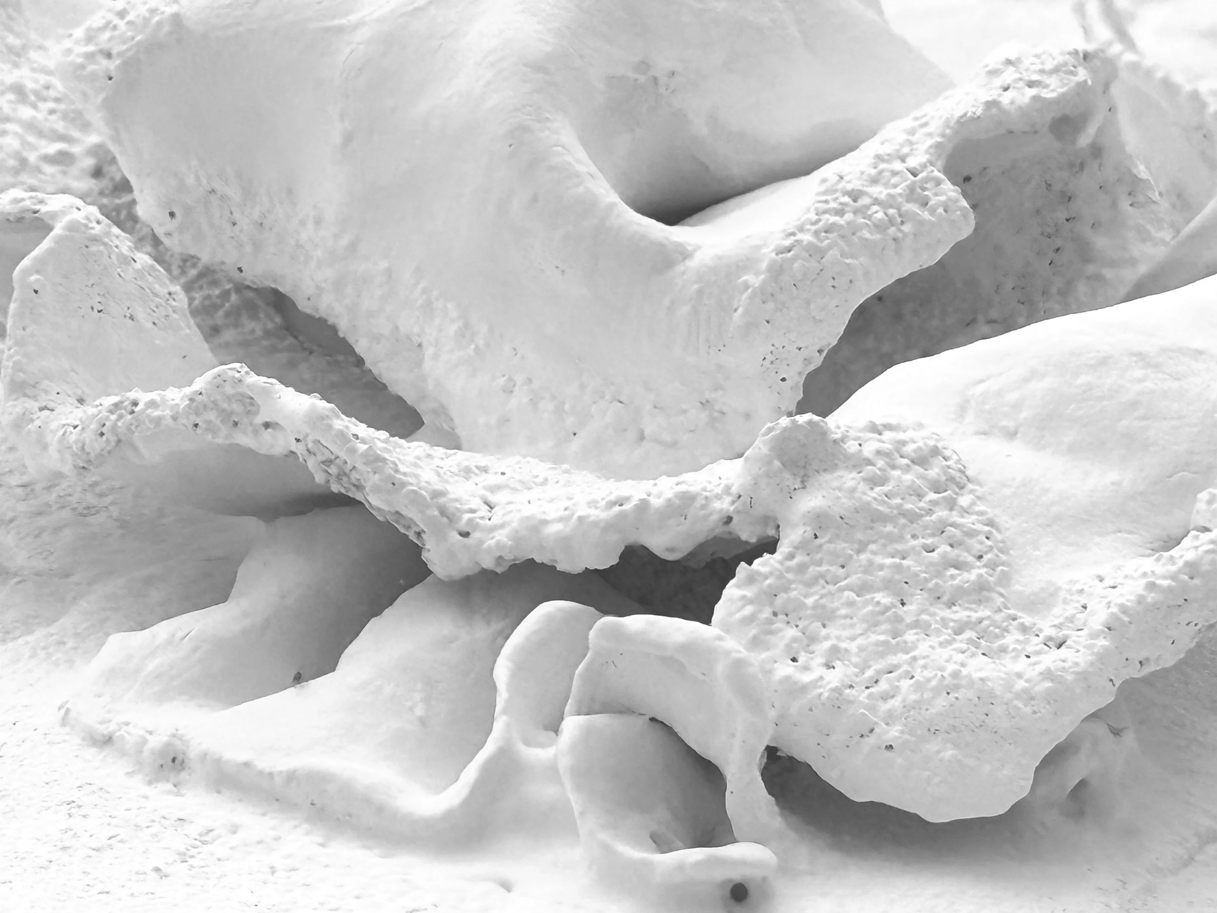 Close-up of snow-covered rocks and ice forming a rugged landscape.
