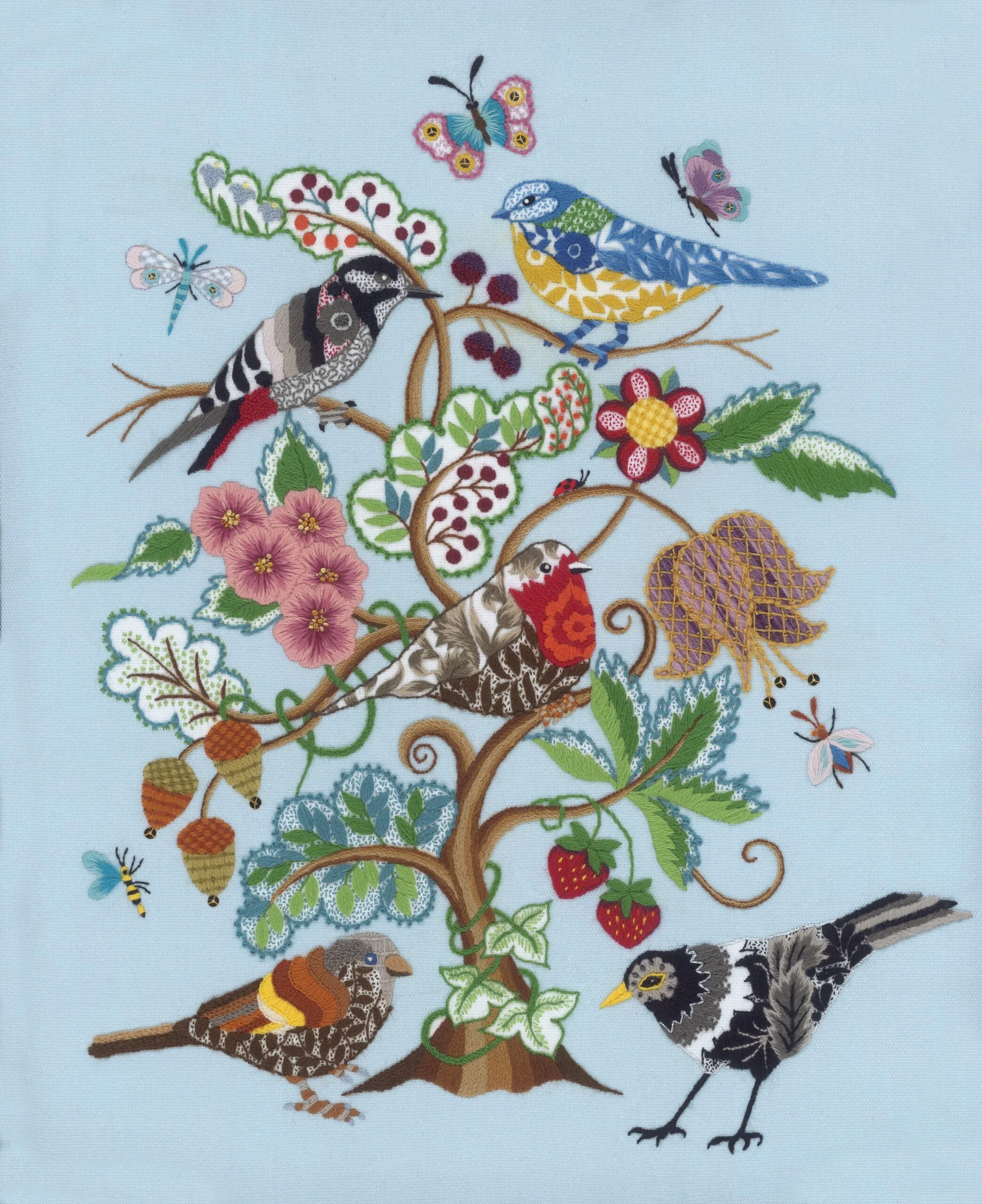 Colorful embroidered artwork of a tree with birds, flowers, and insects against a light blue background.