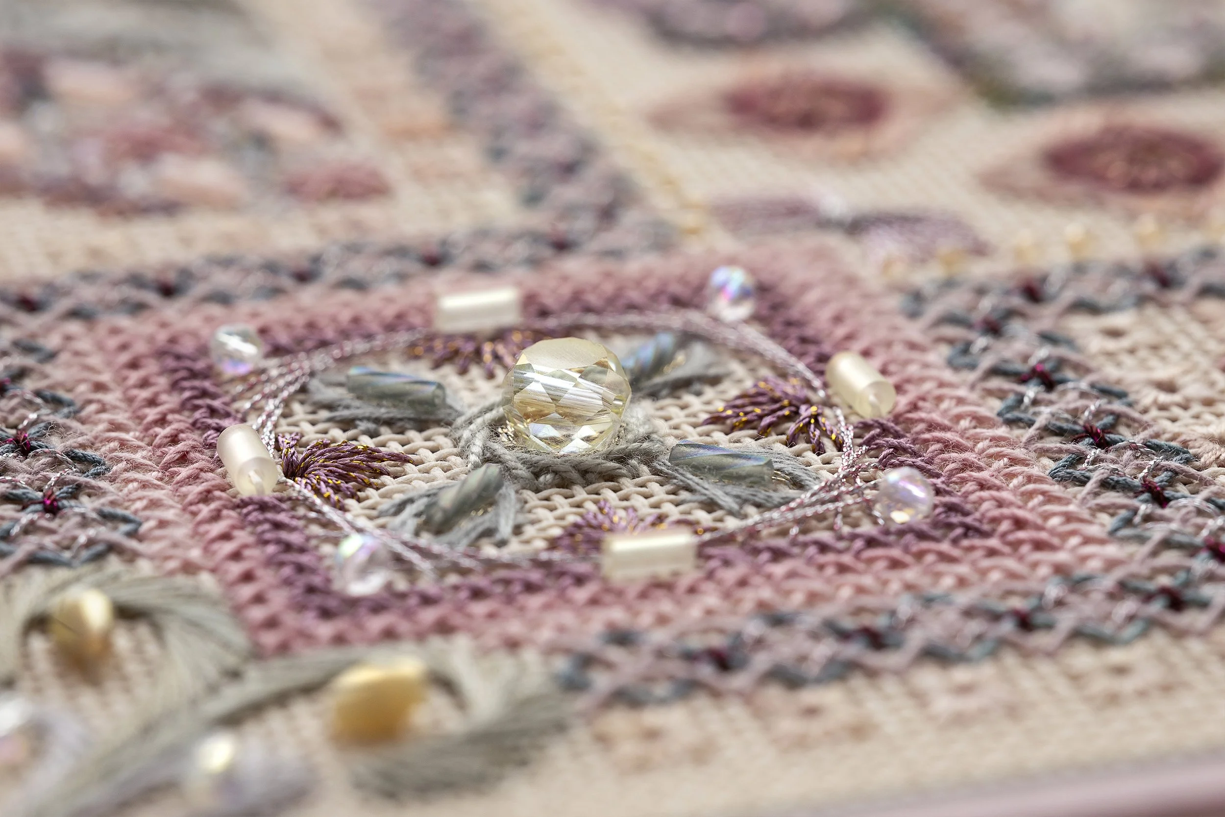 Close-up of a woven textile with decorative beads and crystals.