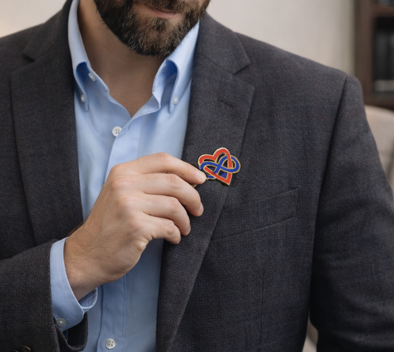 Ryan Minti, non-monogamy expert and mentor adjusting his polyamory pin