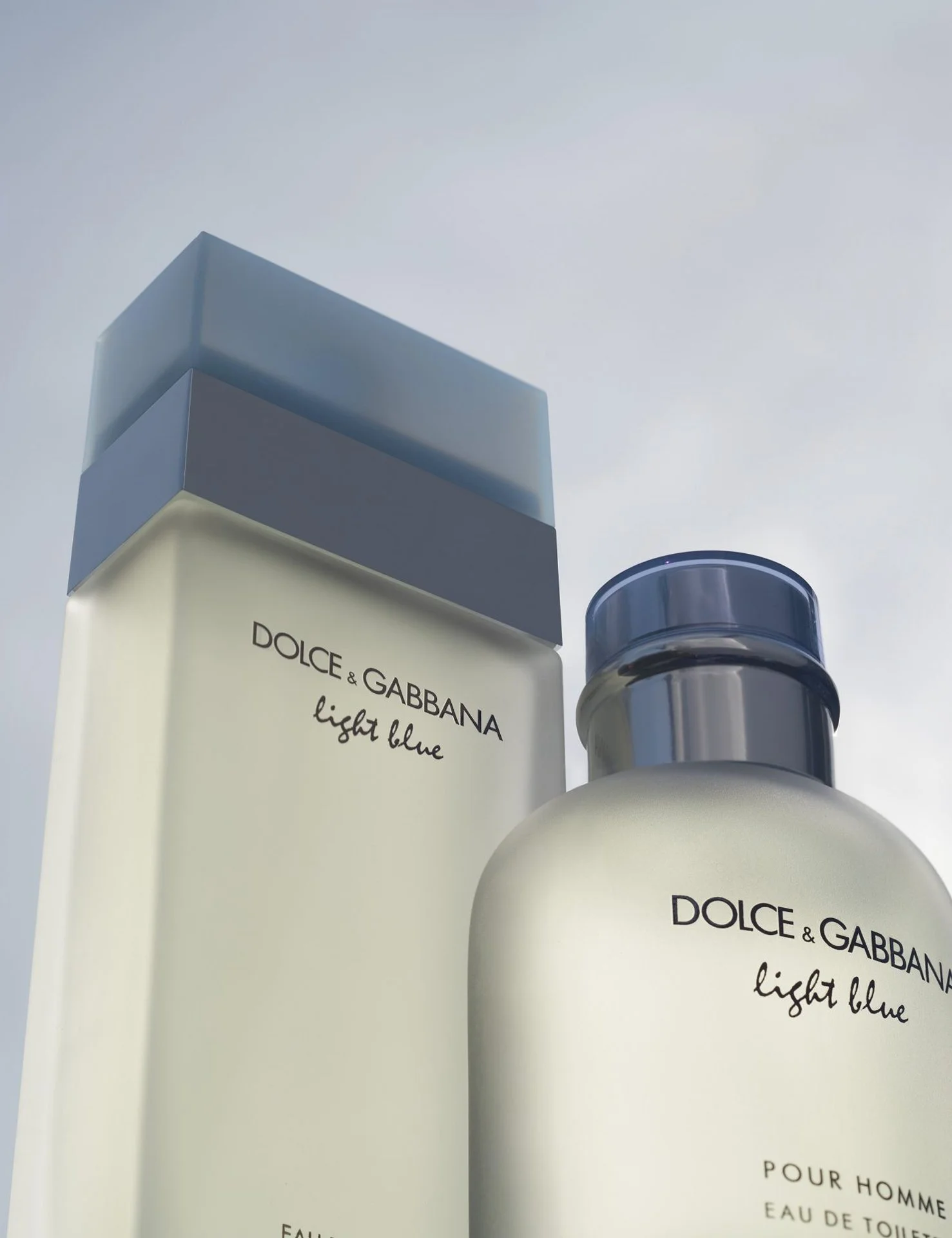 Close-up of a Dolce & Gabbana Light Blue perfume bottle with a black cap, next to the boxed packaging of the same perfume.