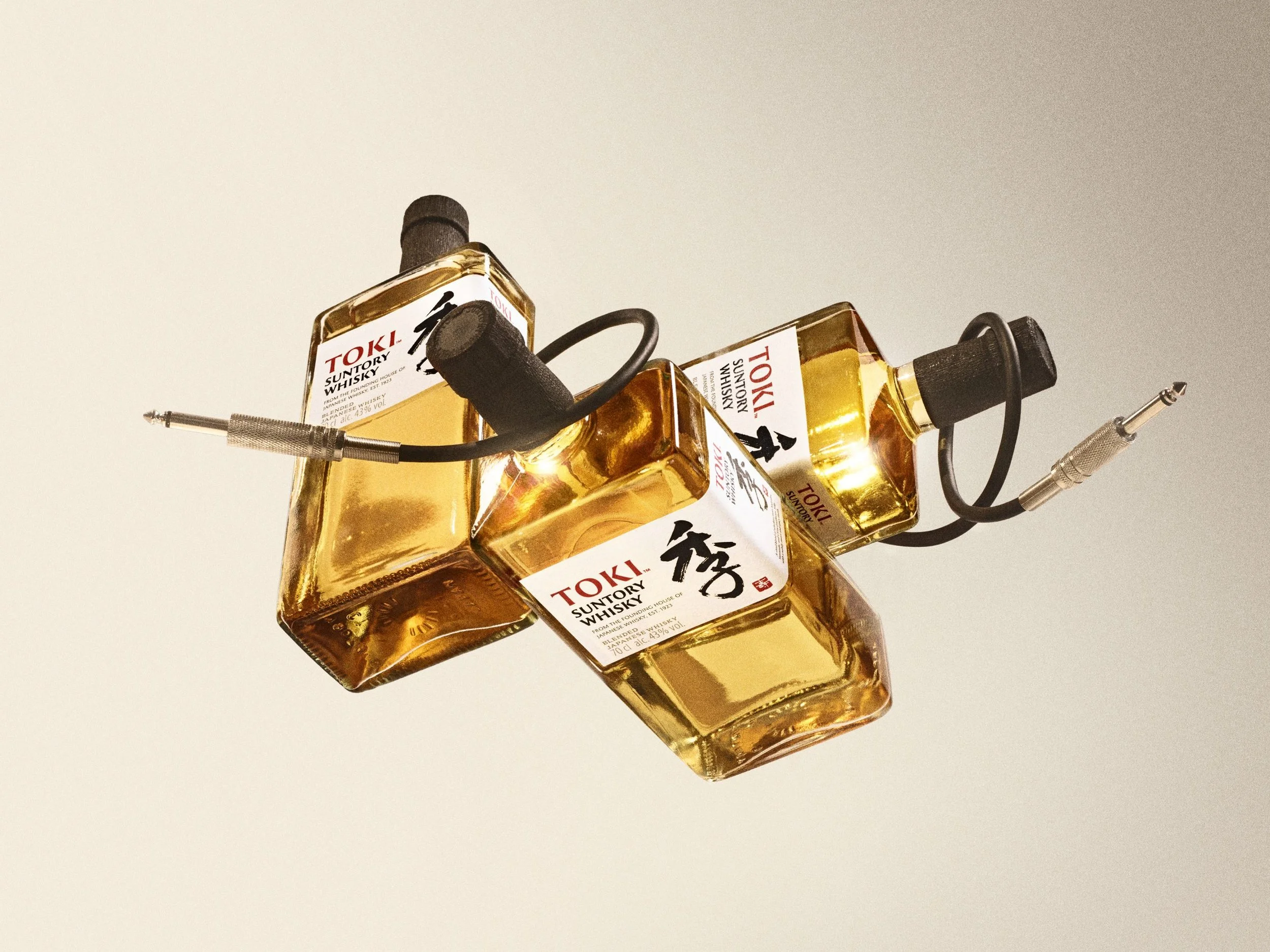 Multiple bottles of Toki Suntory whisky arranged on a white surface, with a microphone in the foreground.