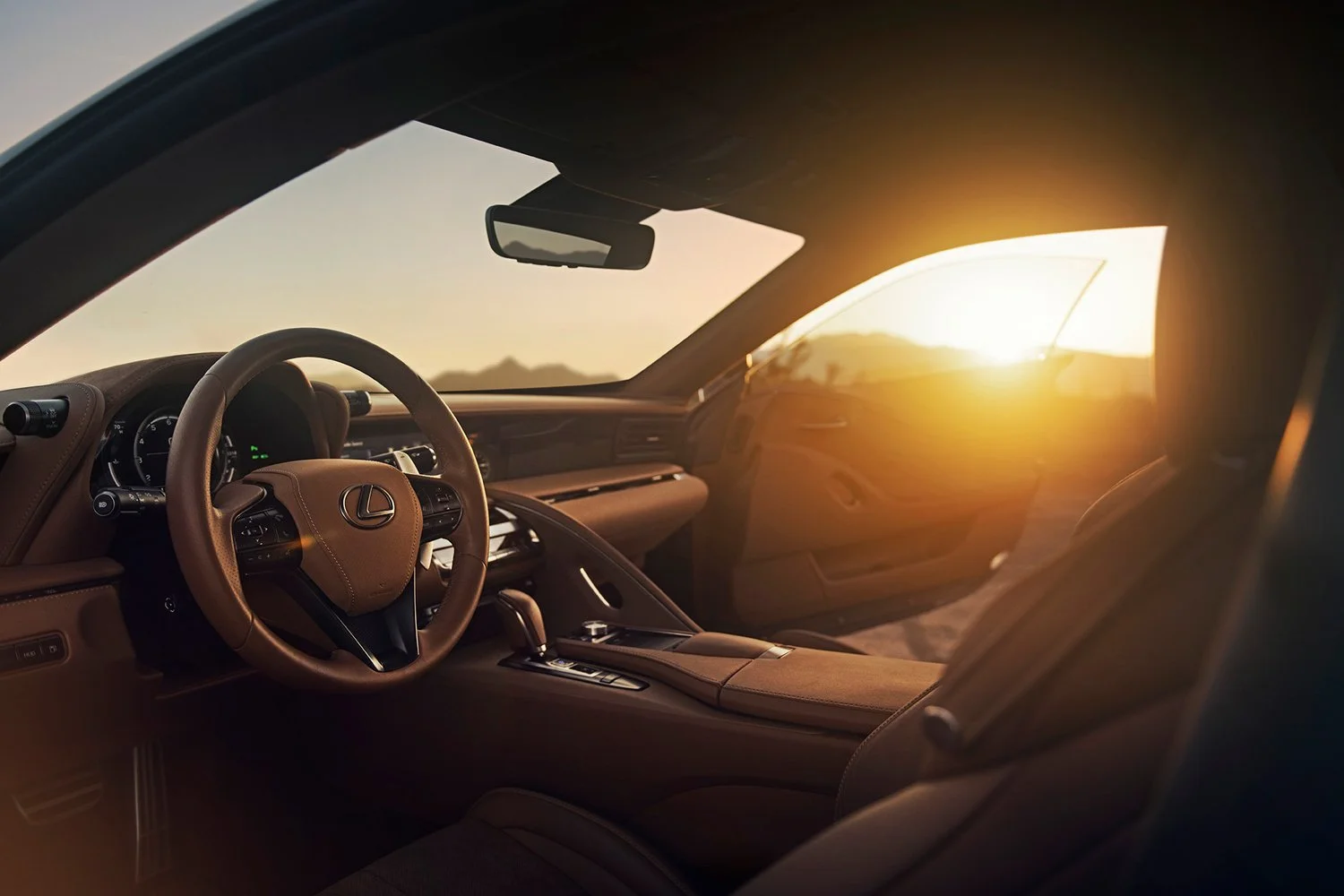 Interior of a luxury Lexus car during sunset with tan leather seats and dashboard
