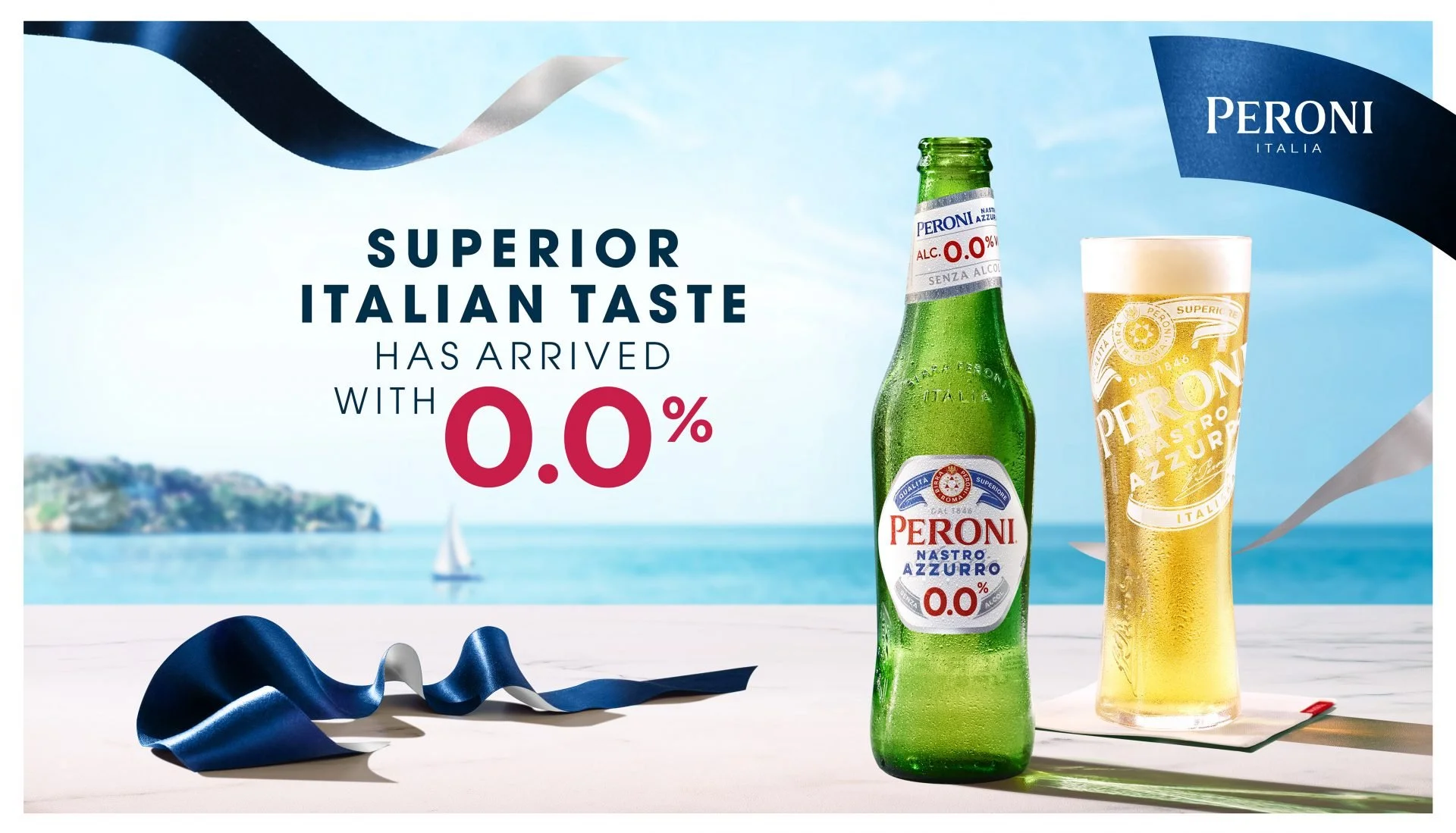 Advertisement for Peroni Nastro Azzurro beer featuring a green beer bottle and a glass of beer on a beach with an ocean and sailboat in the background, with the text 'Superior Italian Taste Has Arrived with 0.0%'.