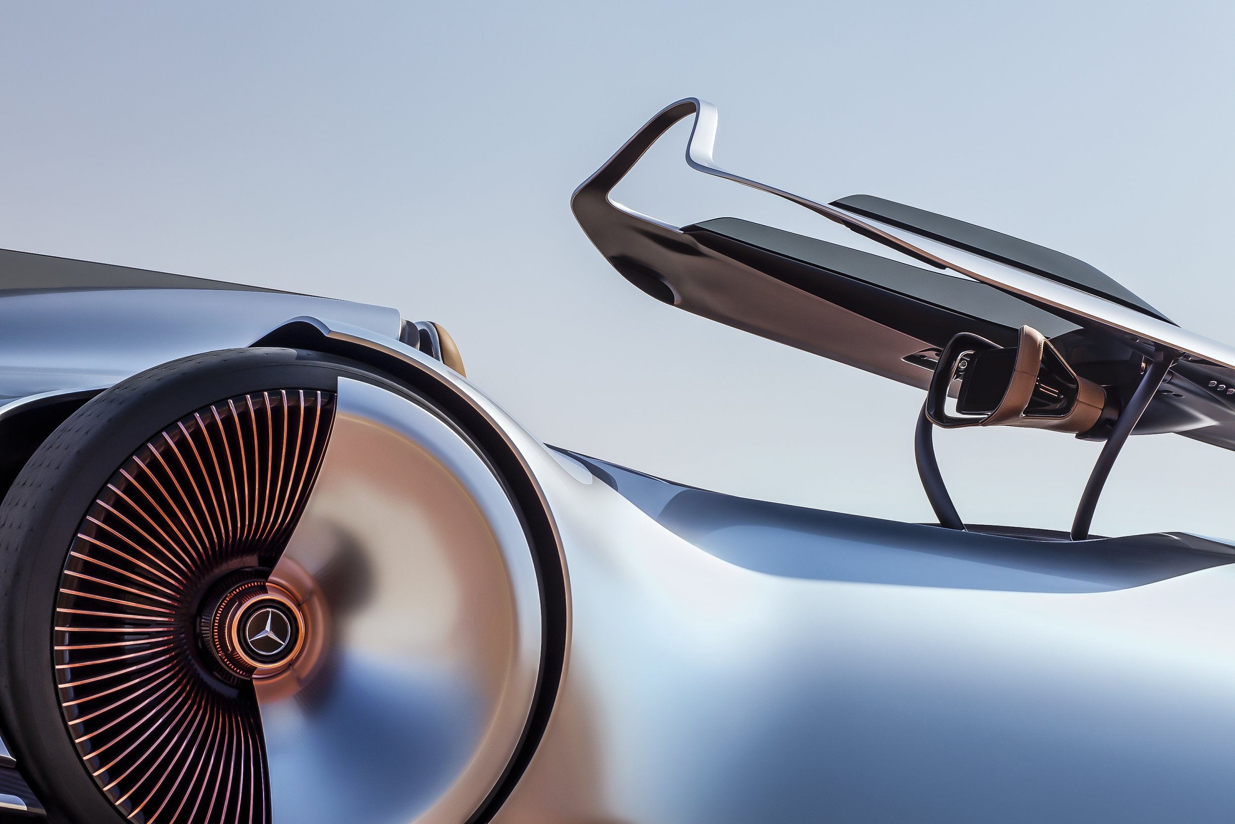 Close-up of a futuristic Mercedes-Benz concept car with sleek design and illuminated wheel detail against a clear sky.