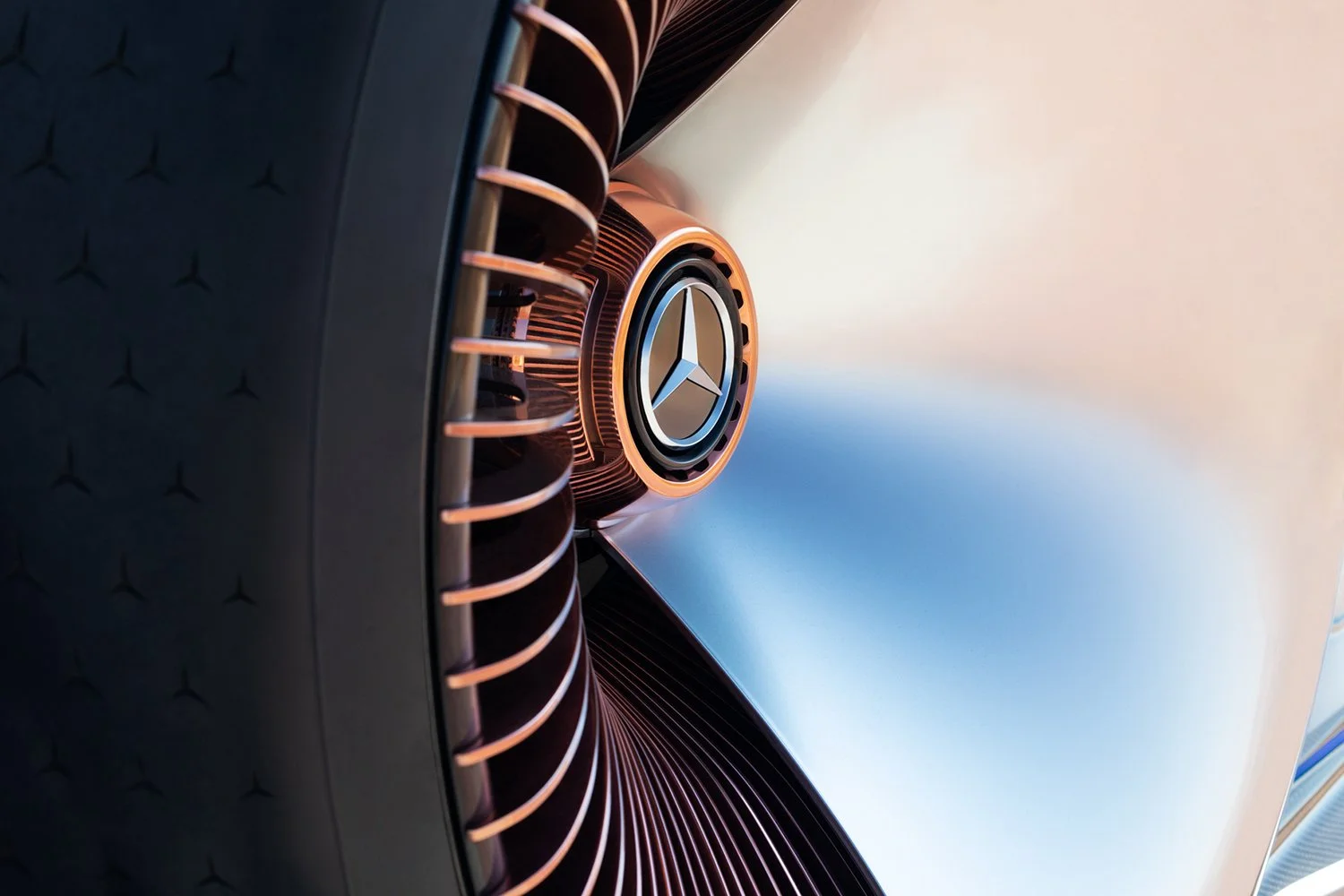 Close-up of the front grille of a silver Mercedes-Benz car, showcasing the emblem and modern design elements.