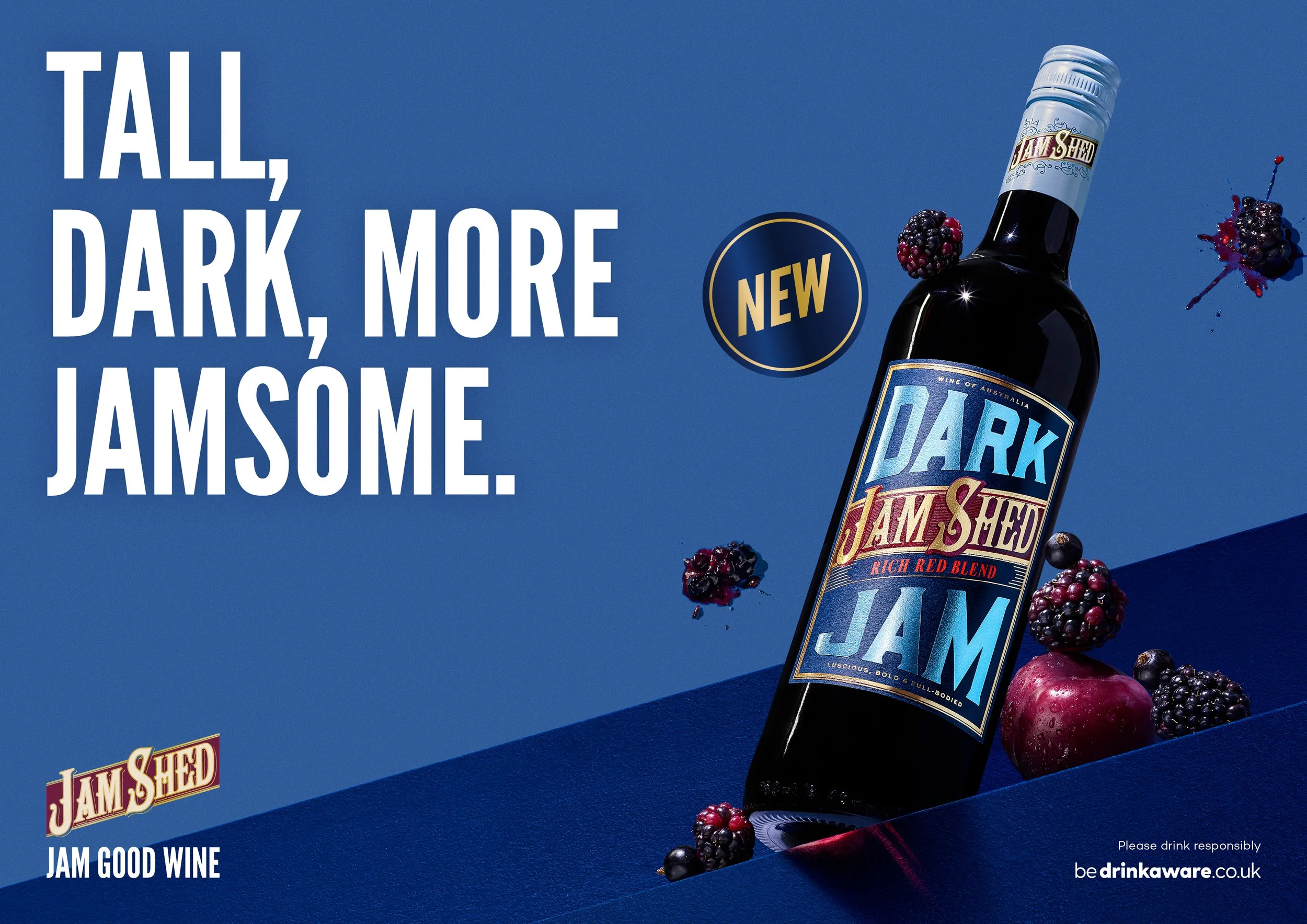 A blue background with white text that reads 'All, dark, more, jamsome.' Next to the text is a bottled wine labeled 'Dark Jam & Shield,' surrounded by blackberries, blueberries, and red apples, with a small logo in the bottom right corner and a message to drink responsibly.