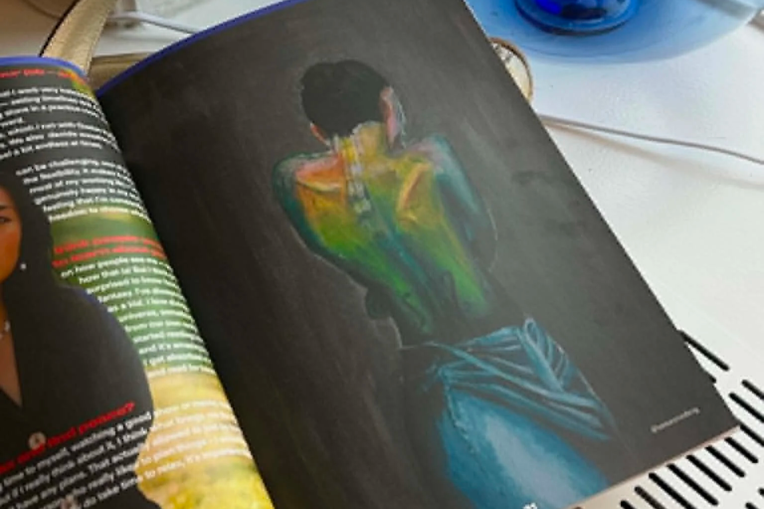 Open Prima Vista Magazine showing a colorful painting of a person from the back, with the f holes in her back on a grey background.