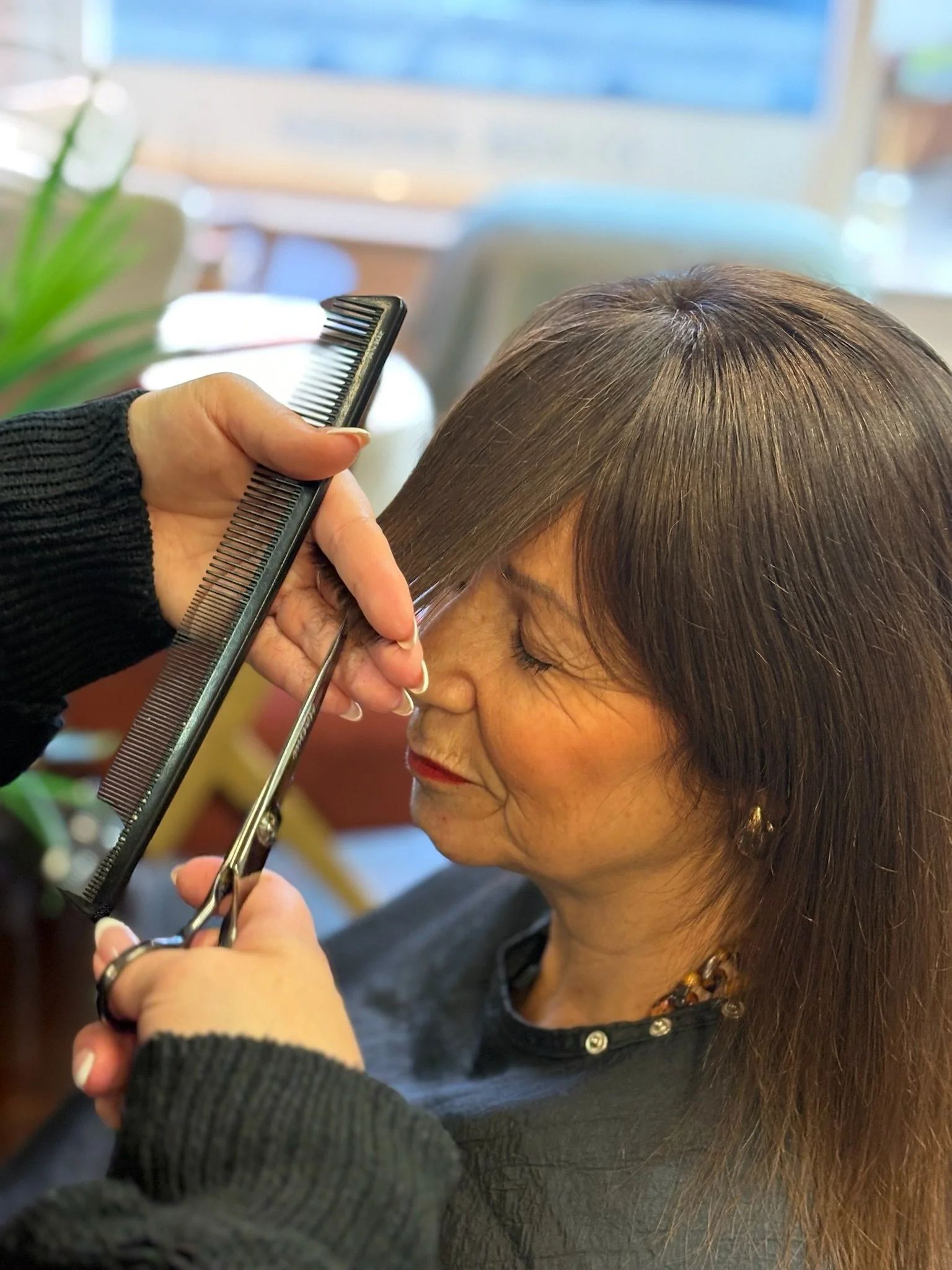 Stylist offering a cut and finish at Tranquillity Hair salon in Street, Somerset