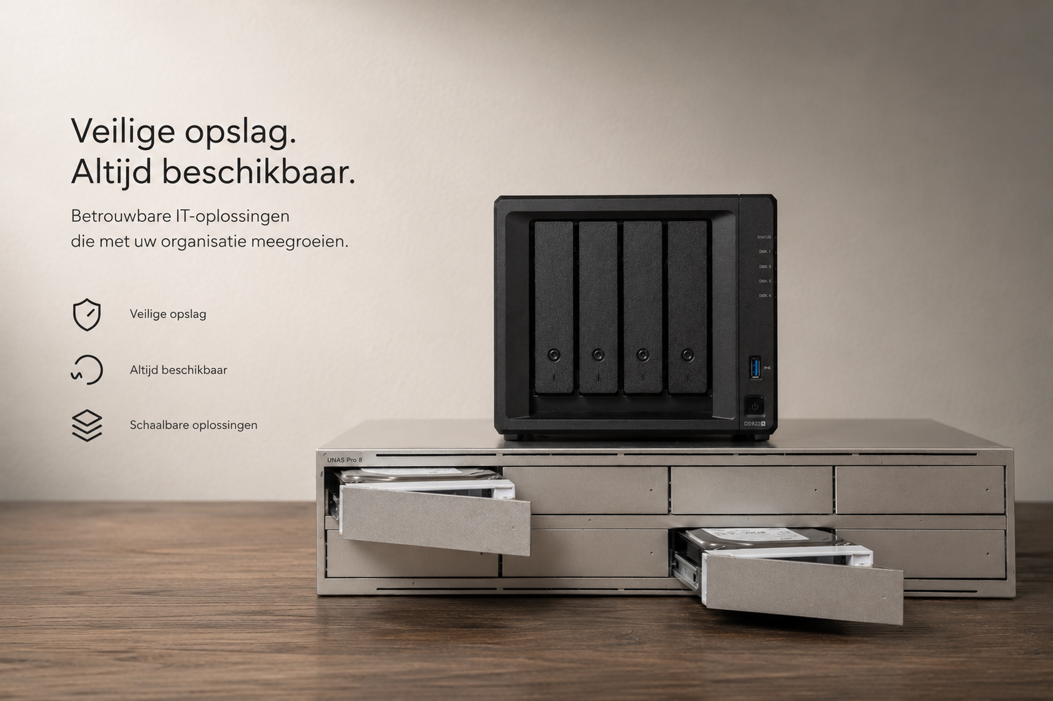 Een beveiligde opslagkast met vier harde schijfbehuizingen staat op een houten tafel, naast een kleine server. Op de linker muur staan pijlen met teksten: 'Veilige opslag', 'Altijd beschikbaar' en 'Schaalbare oplossingen'.