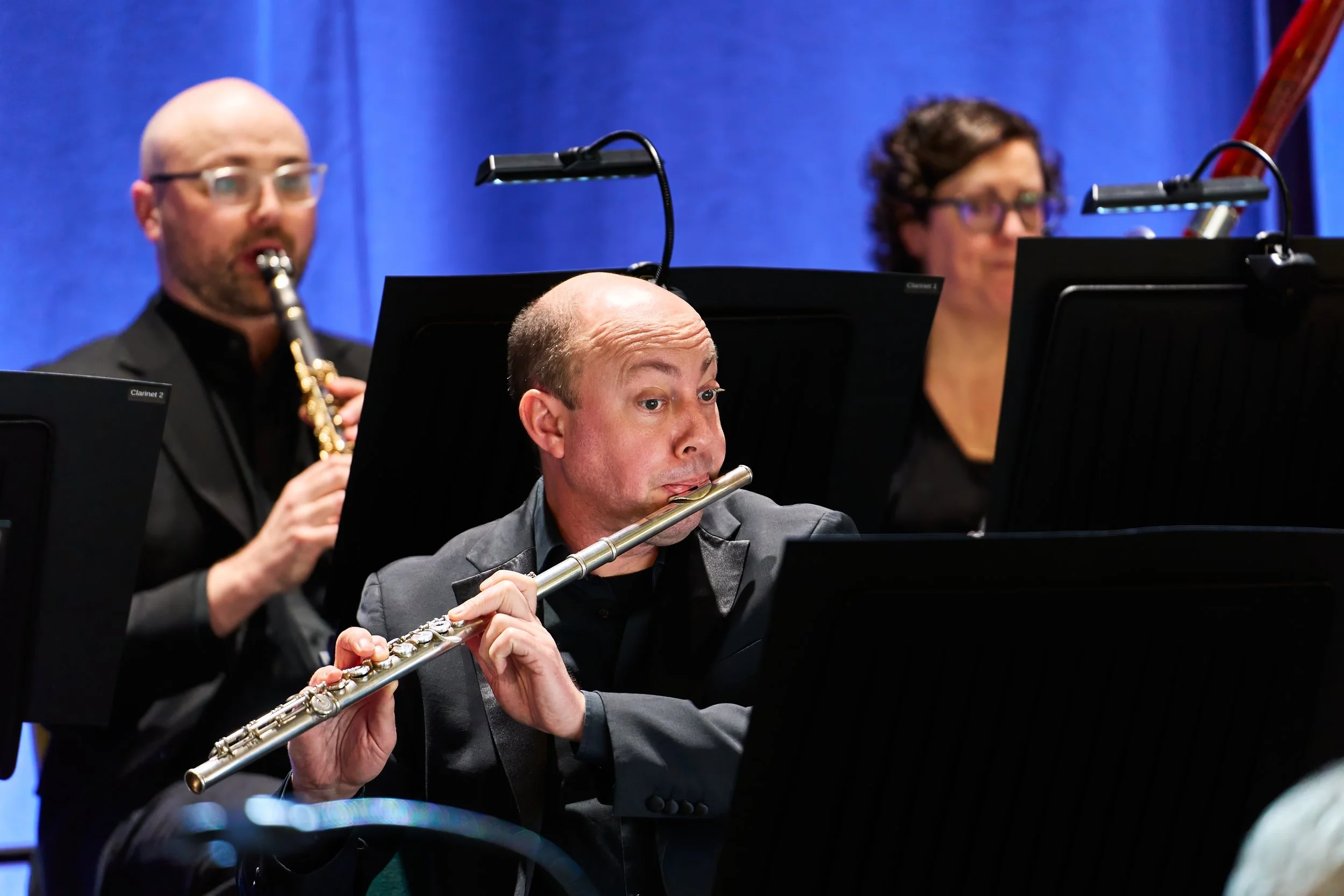 Flautist Ian Mullin playing on stage with Bath Philharmonic Orchestra.