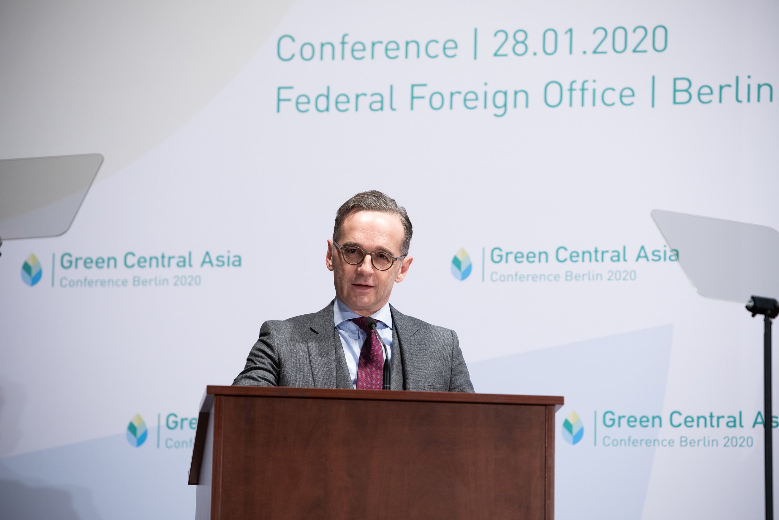 Außenminister Heiko Maas steht hinter einem Rednerpult bei einer Konferenz am 28.01.2020 im Bundeskanzleramt in Berlin. Der Hintergrund zeigt das Logo der Konferenz "Green Central Asia".