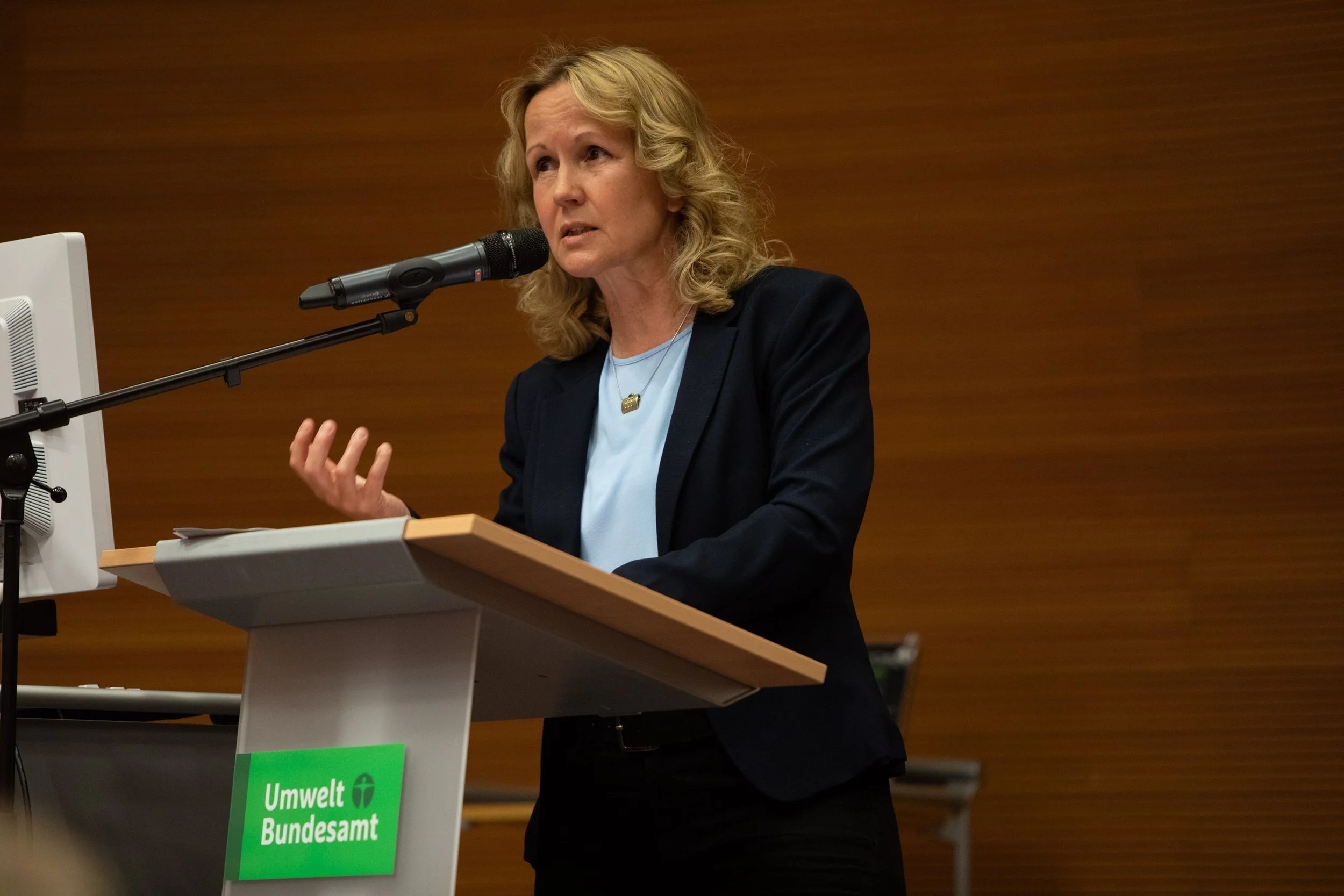 Umweltministerin Steffi Lemke spricht bei einer Veranstaltung des Bundesamtes für Umwelt, sichtbar hinter einem Rednerpult mit einem grünen Schild, auf dem steht "Umwelt Bundesamt".