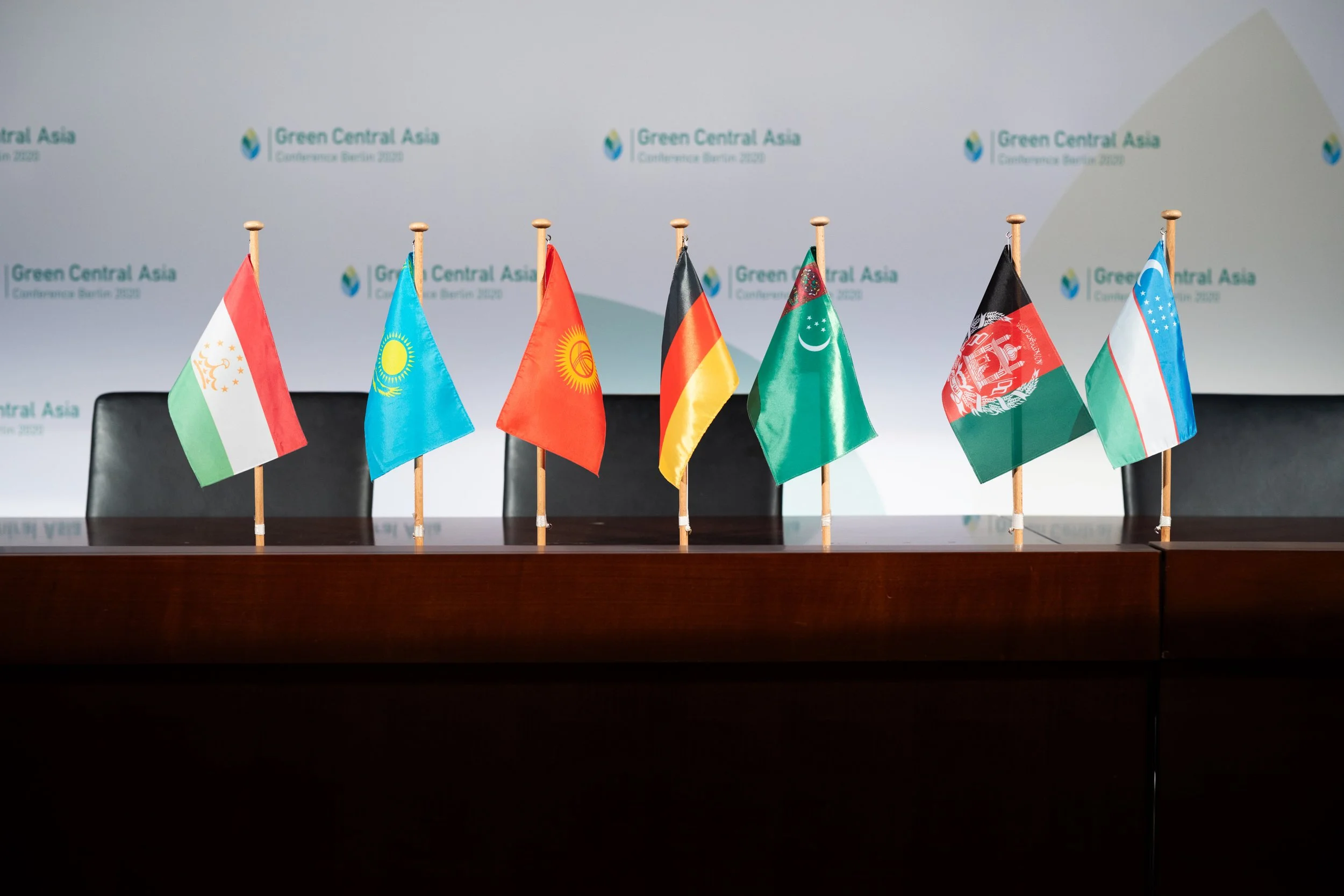 Mehrere kleine Flaggen verschiedener Länder auf Tischen bei der Green Central Asia Konferenz in Berlin 2020.