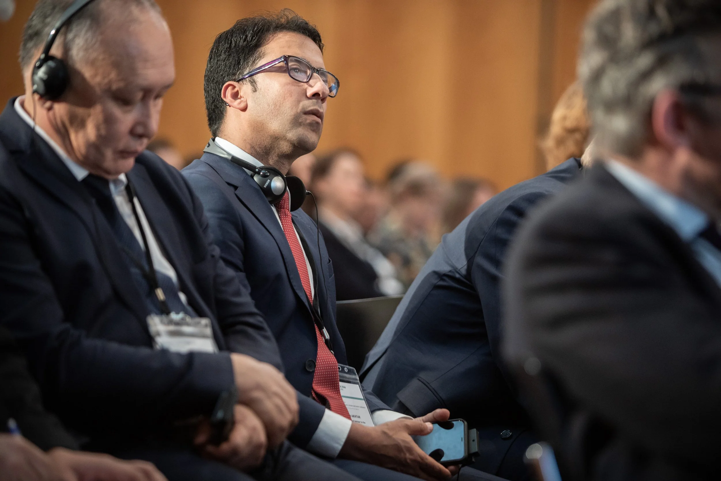Menschen in Anzügen hören auf der Berlin Climate-Security-Konferenz zu, einige tragen Headsets, sitzen im Weltsaal des Außenministeriums.