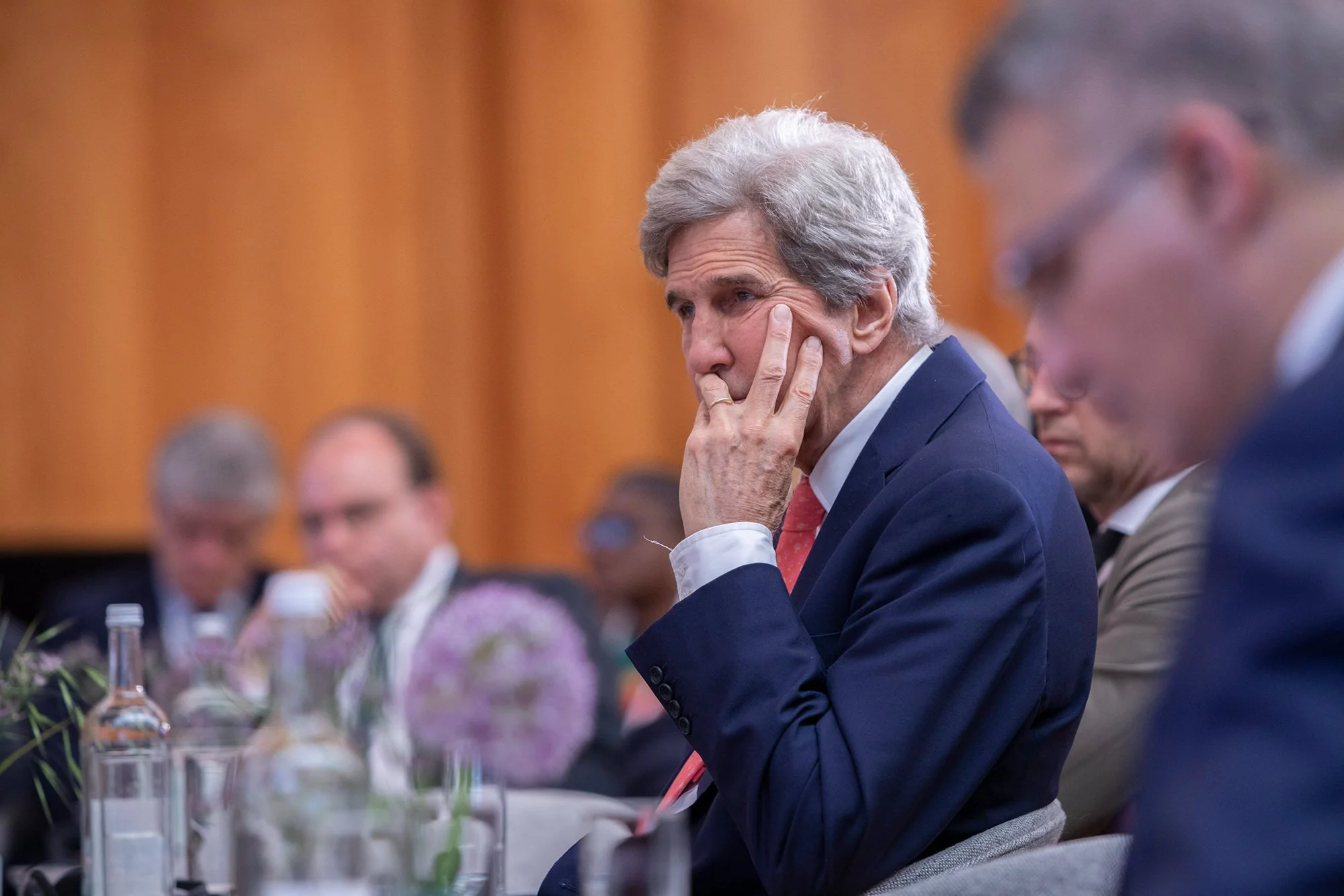John Kerry sitzt bei der Berlin-Climate-Security-Conference im Publikum und hört aufmerksam zu.