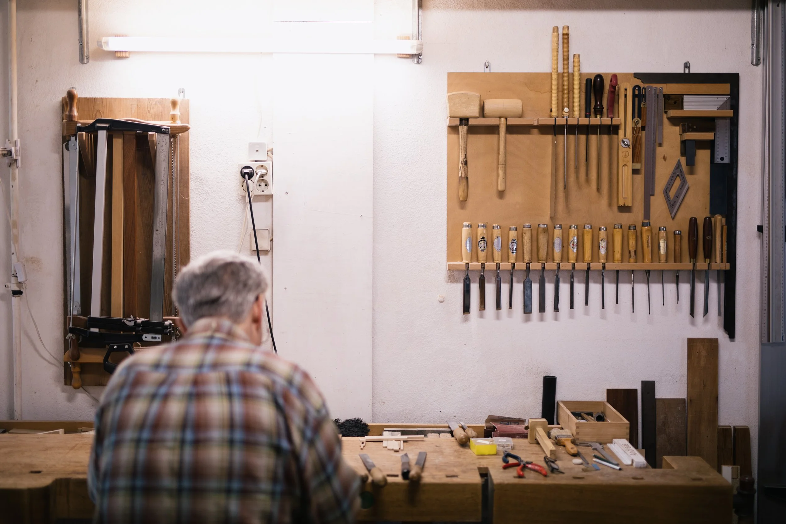 Werkzeugschrank mit Hammer, Meißel, Schraubenzieher und anderen Handwerkzeugen an der Werkbank.