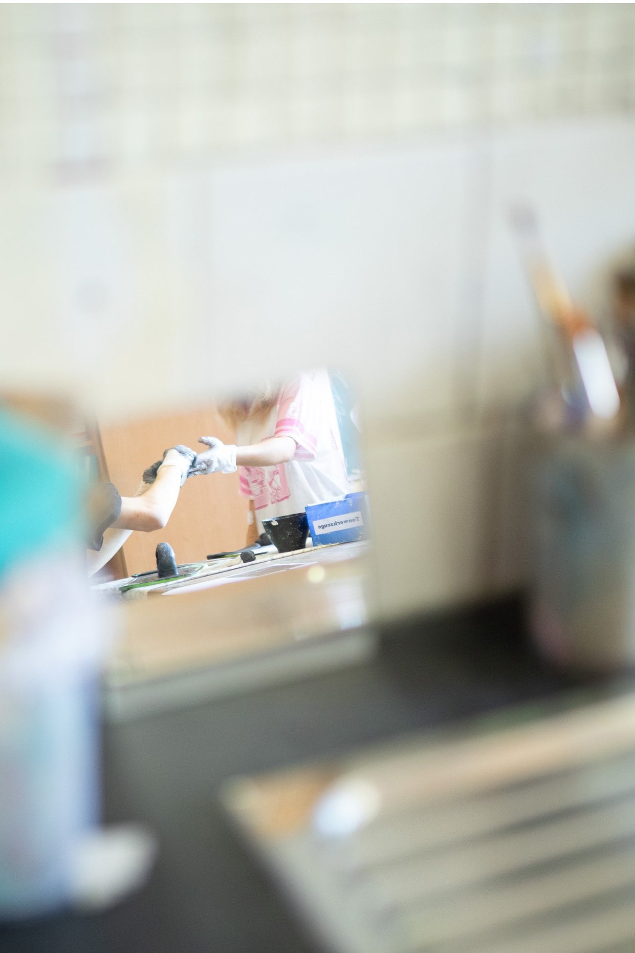 Junge Kinder in einer Küche, die beim Kochen helfen, mit einem Blick durch ein Fenster