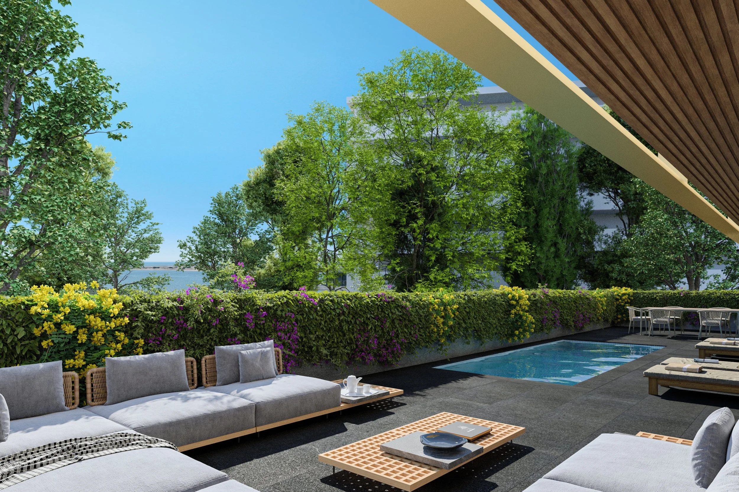 Outdoor patio area with lounge seating, a swimming pool, and lush green trees and flowering bushes under a pergola.