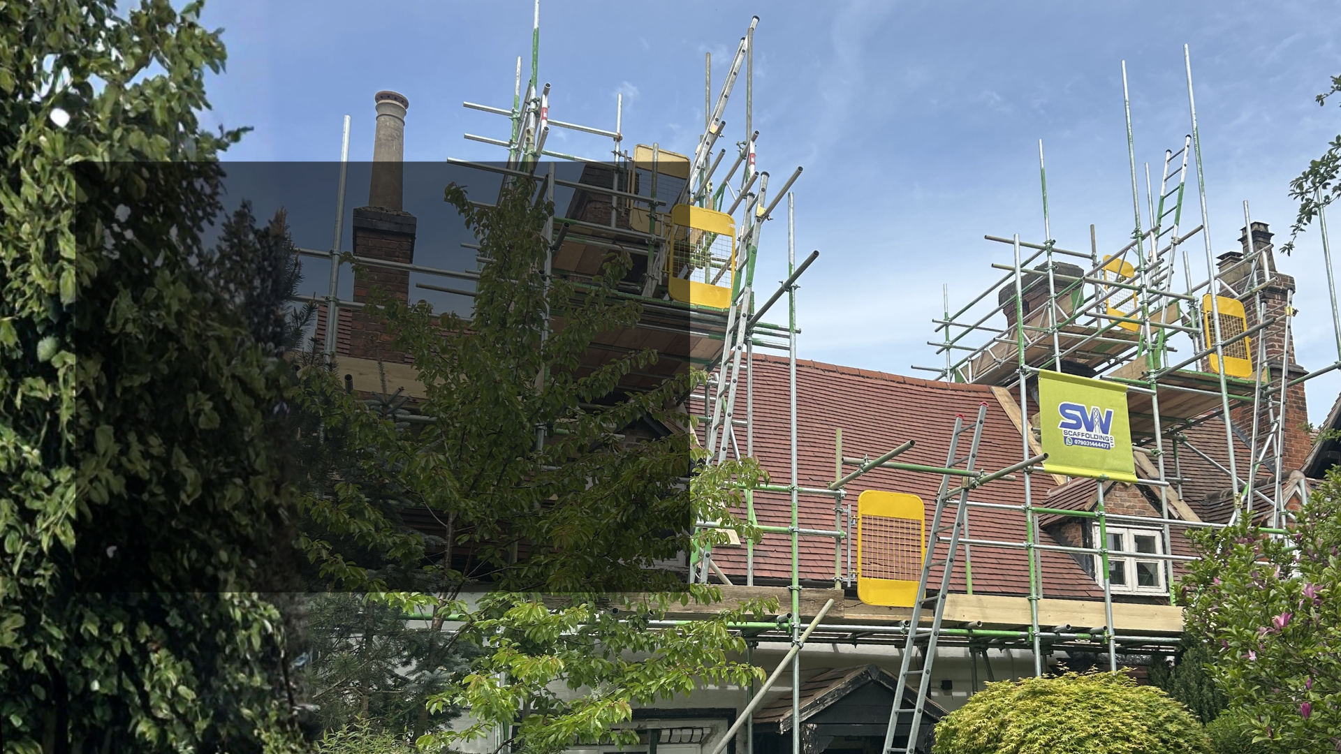 Construction scaffolding set up on a residential building with a red tile roof and chimney.  Domestic Scaffolding service from SW Scaffolding.