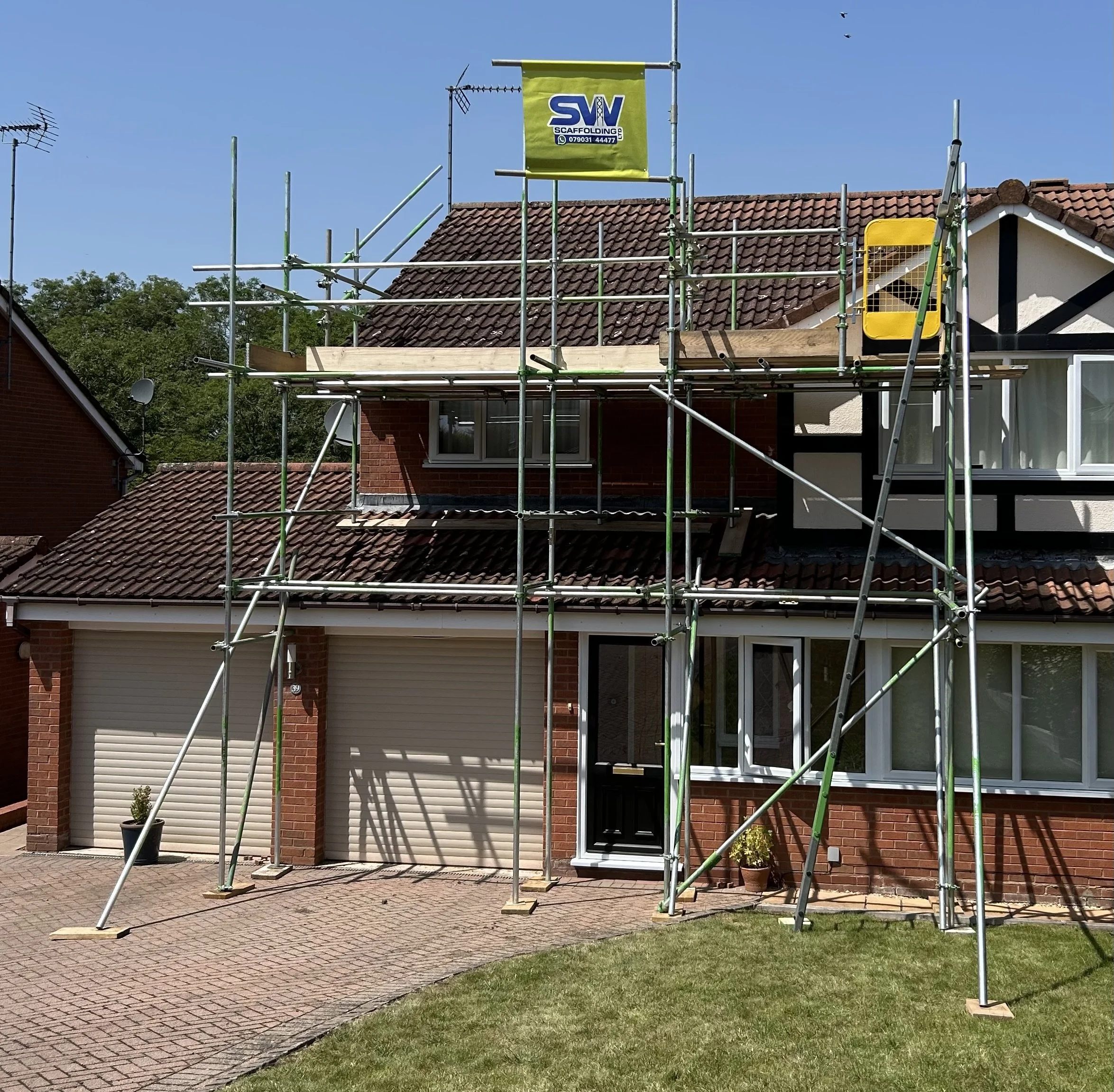 House under construction with scaffolding around the front, a brick exterior, and a tiled roof.  Domestic Scaffolding service from SW Scaffolding