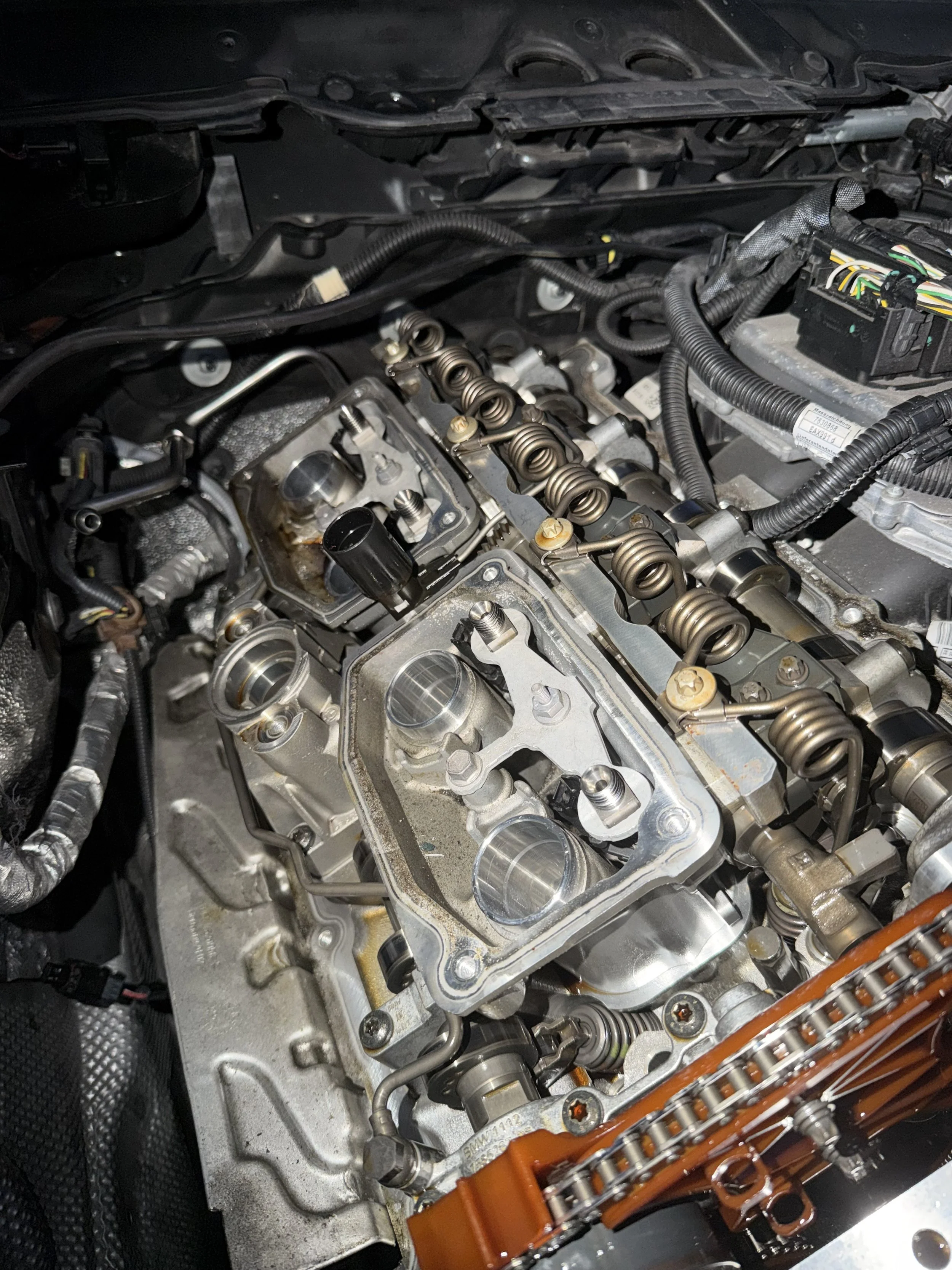 Close-up view of an engine with the valve cover removed, showing the valve train and camshaft components.