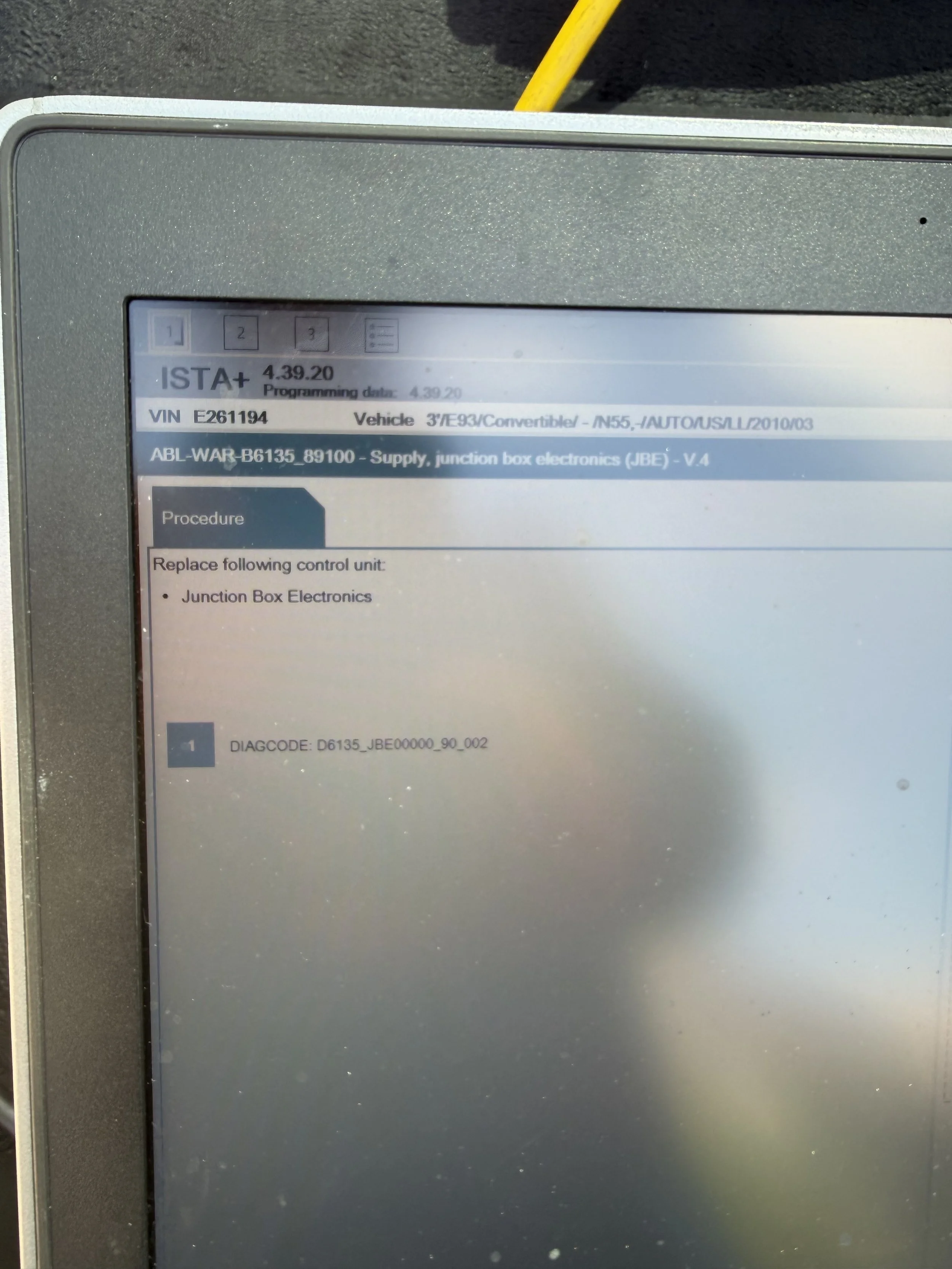 A close-up of a digital screen displaying vehicle information, including a VIN number, vehicle model, and a technical procedure related to junction box electronics.