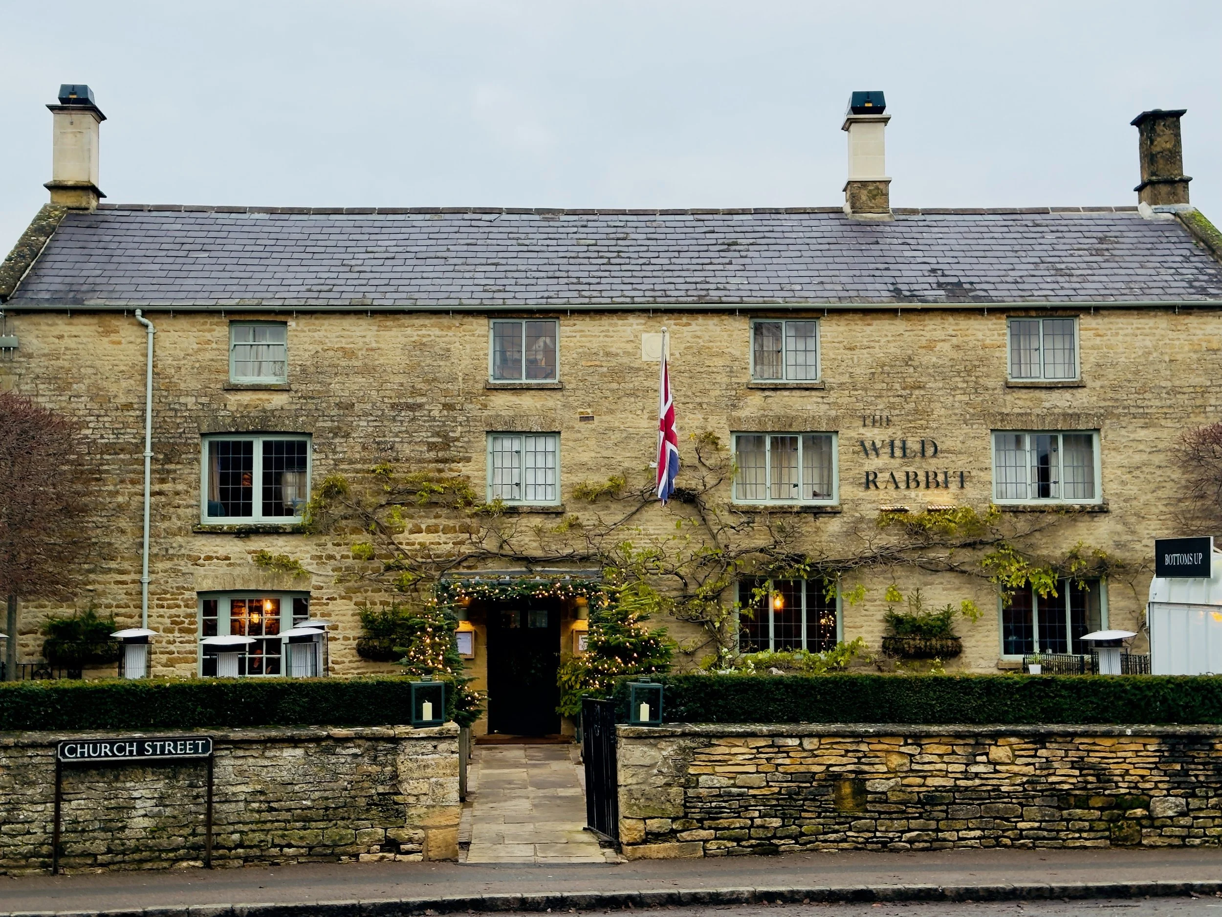 An image of a pub in the UK on Church Street in Kingham. With a sign that says The Wild Rabbit.